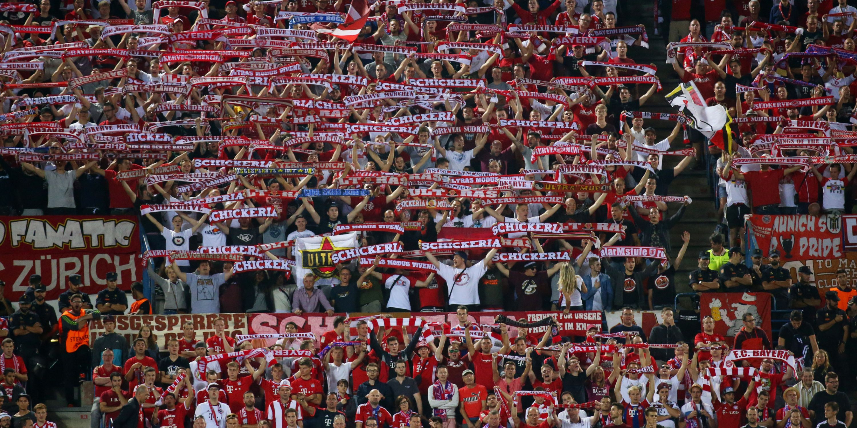 Bayern Munich fans hold up their scarves in song