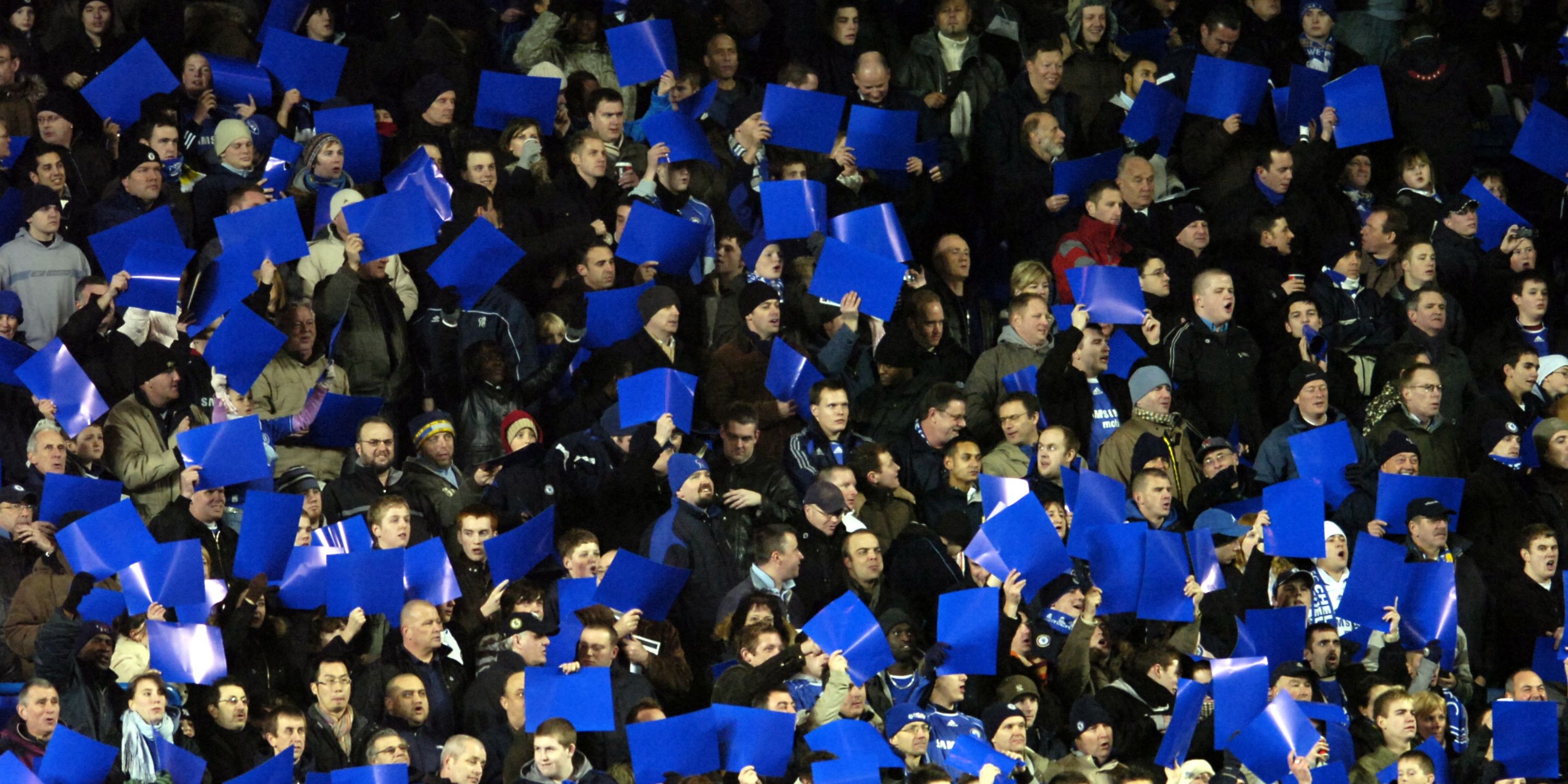Chelsea fans holding up blue posters