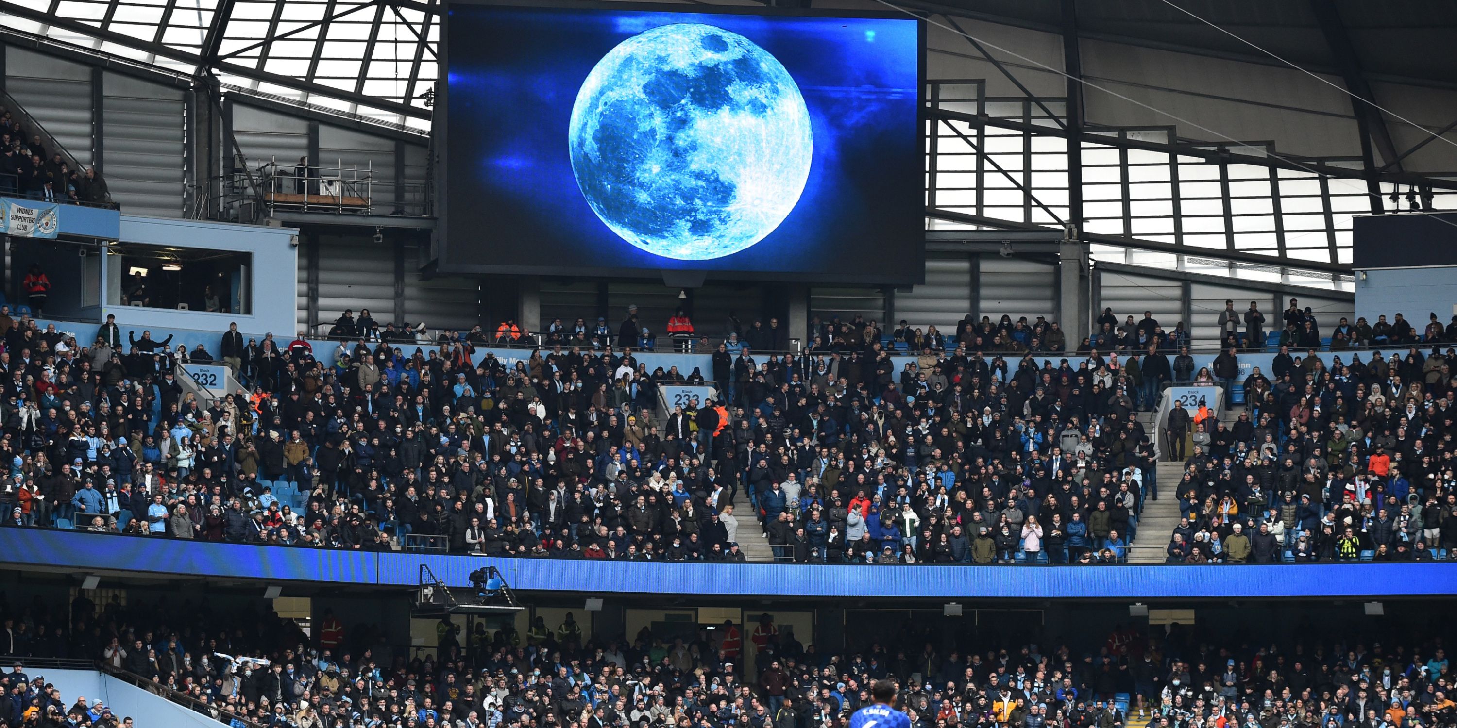 An image of blue moon beamed onto a screen in Manchester City's stadium