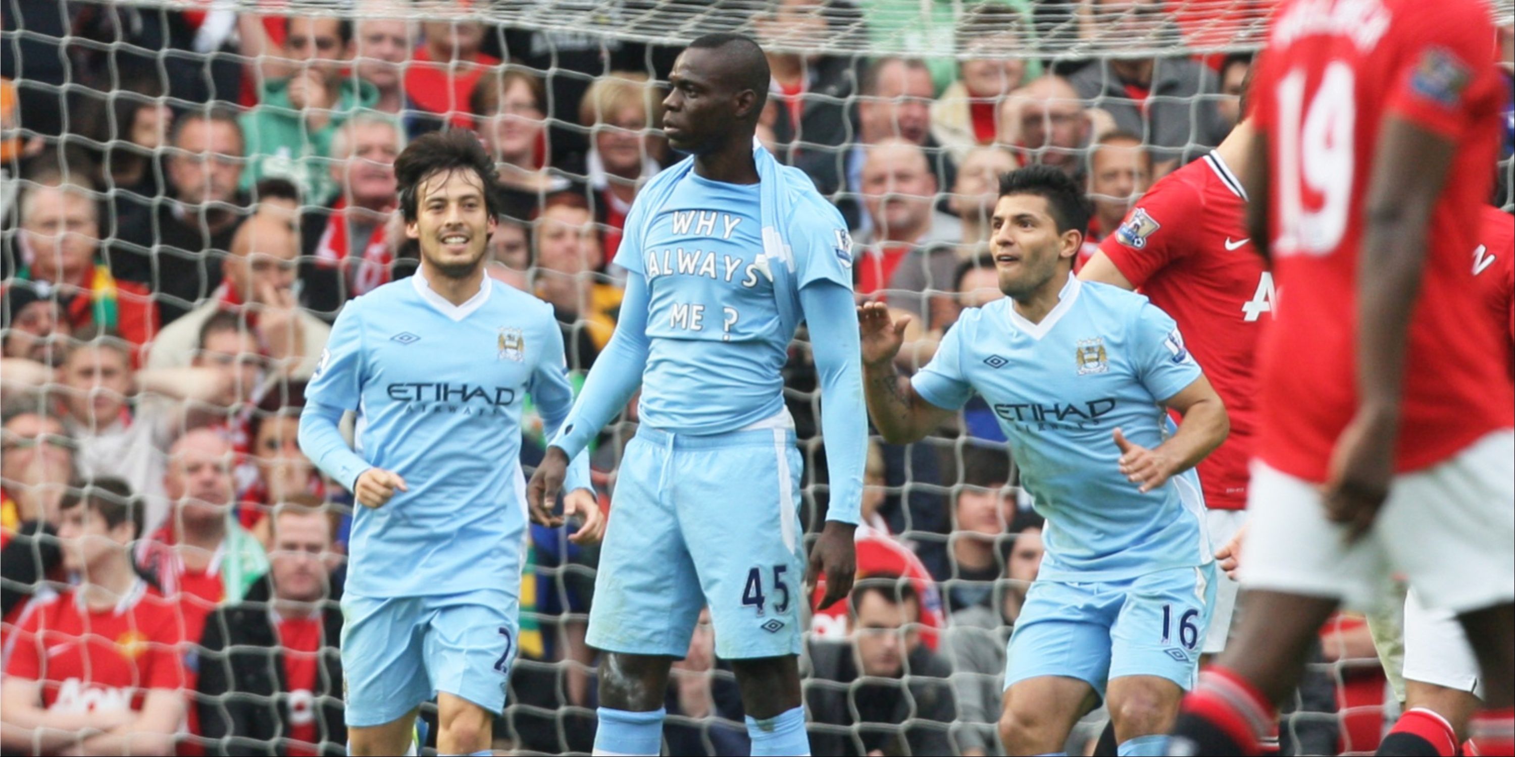 Manchester City's Mario Balotelli reveals a vest saying 'Why always me?' after scoring against Manchester United.
