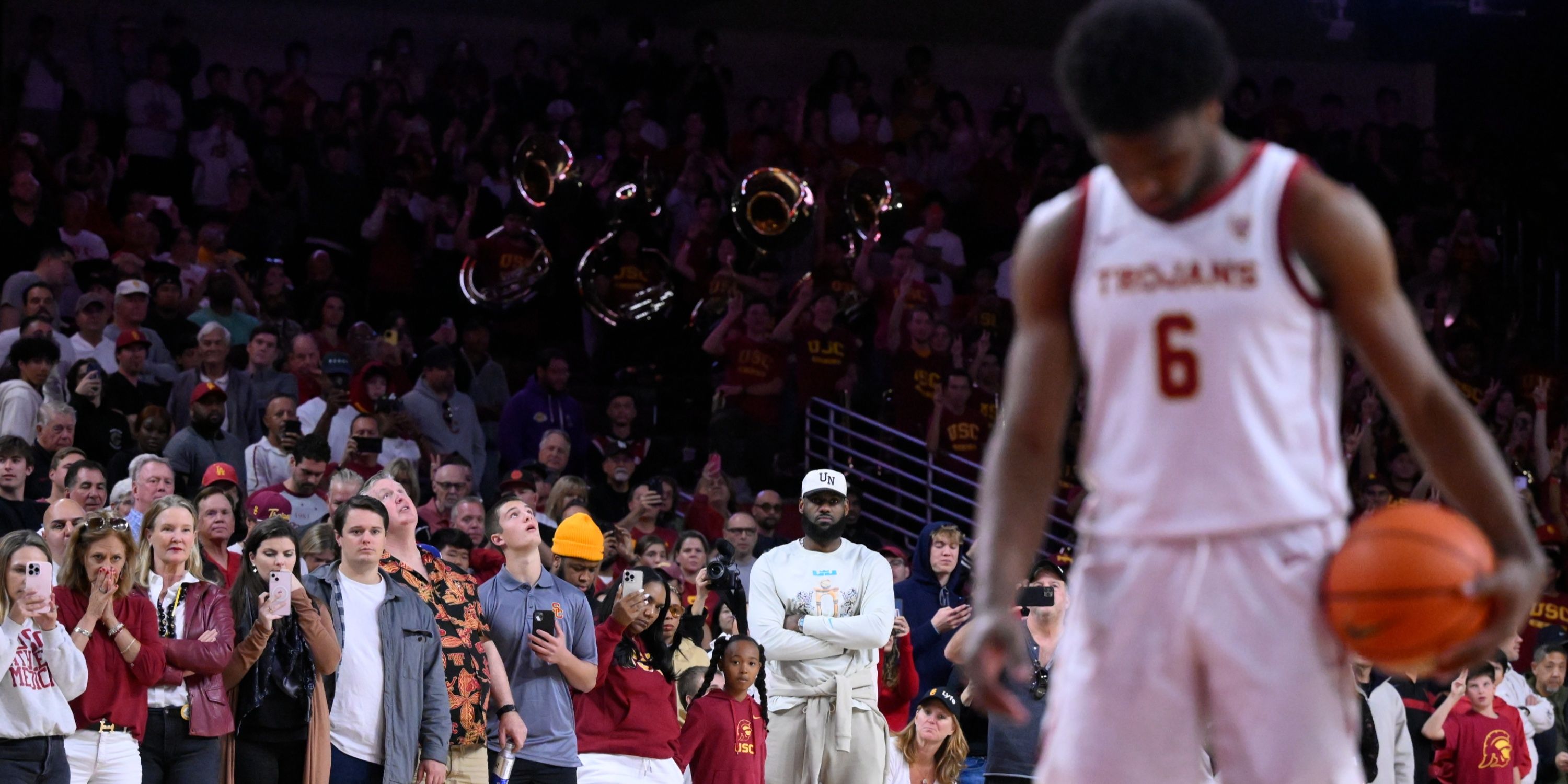 Bronny James shoots free-throw while LeBron James watches from crowd