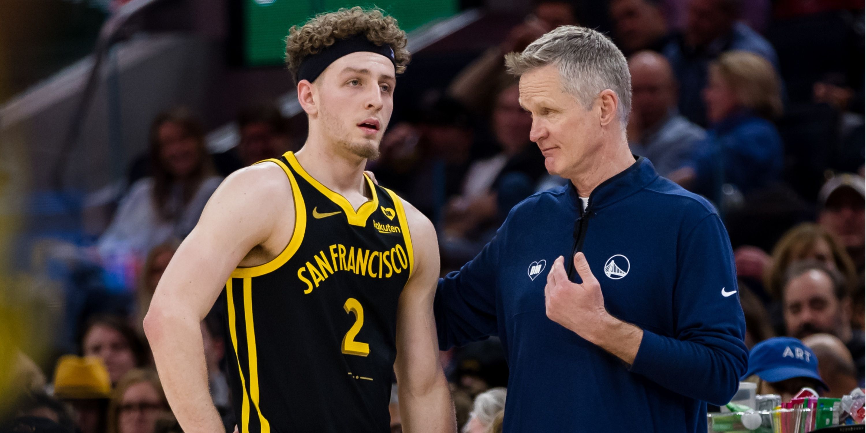 Rookie Warriors player Brandin Podziemski talking with Warriors head coach Steve Kerr during a game against the Los Angeles Clippers.