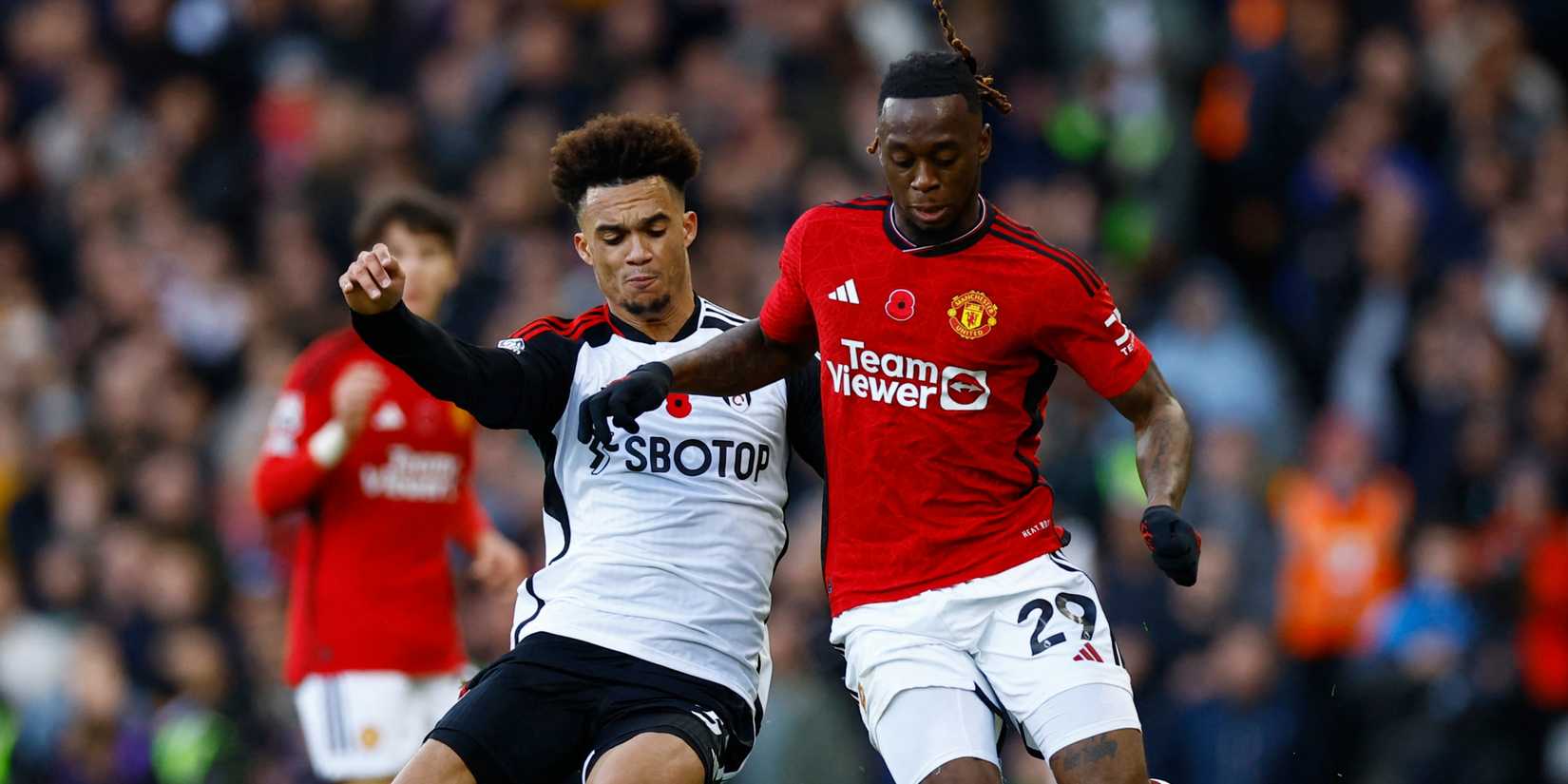 Fulham left-back Antonee Robinson and Manchester United right-back Aaron Wan-Bissaka battling for possession