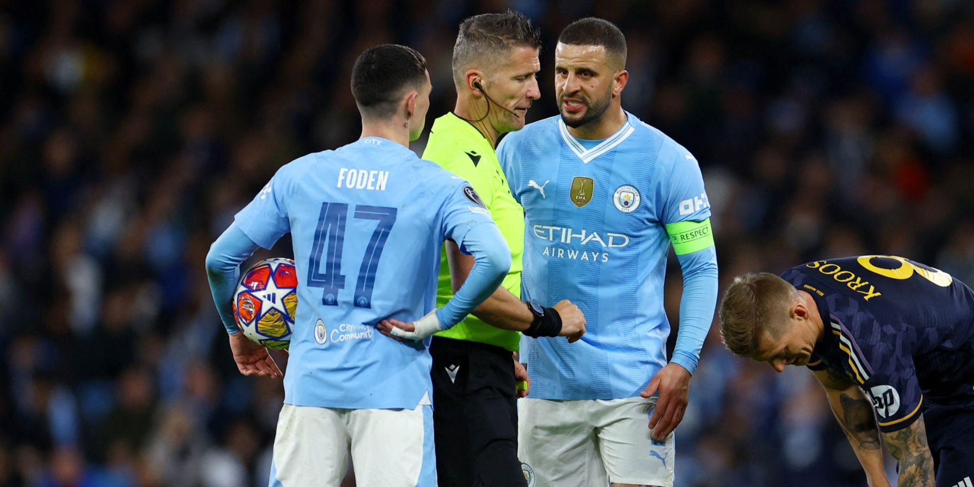 Referee Daniele Orsato talks to Manchester City's Kyle Walker and Phil Foden