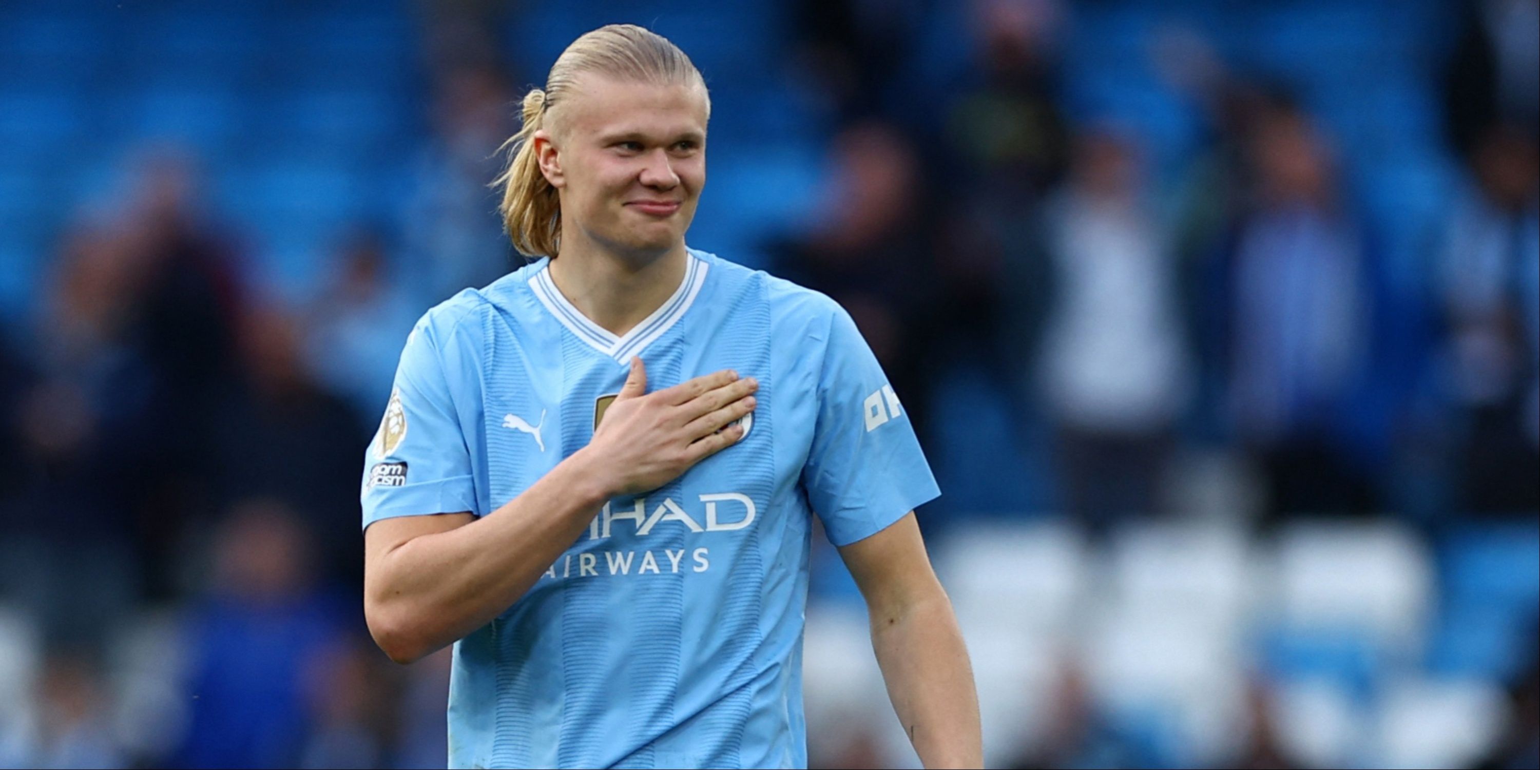 Erling Haaland taps the Manchester City badge on his chest.