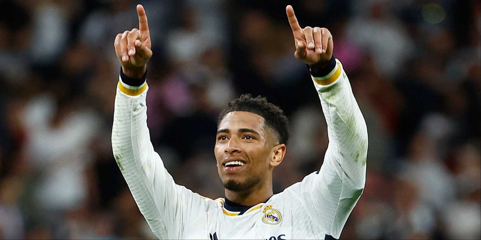 A smiling Jude Bellingham points to the Real Madrid supporters. 