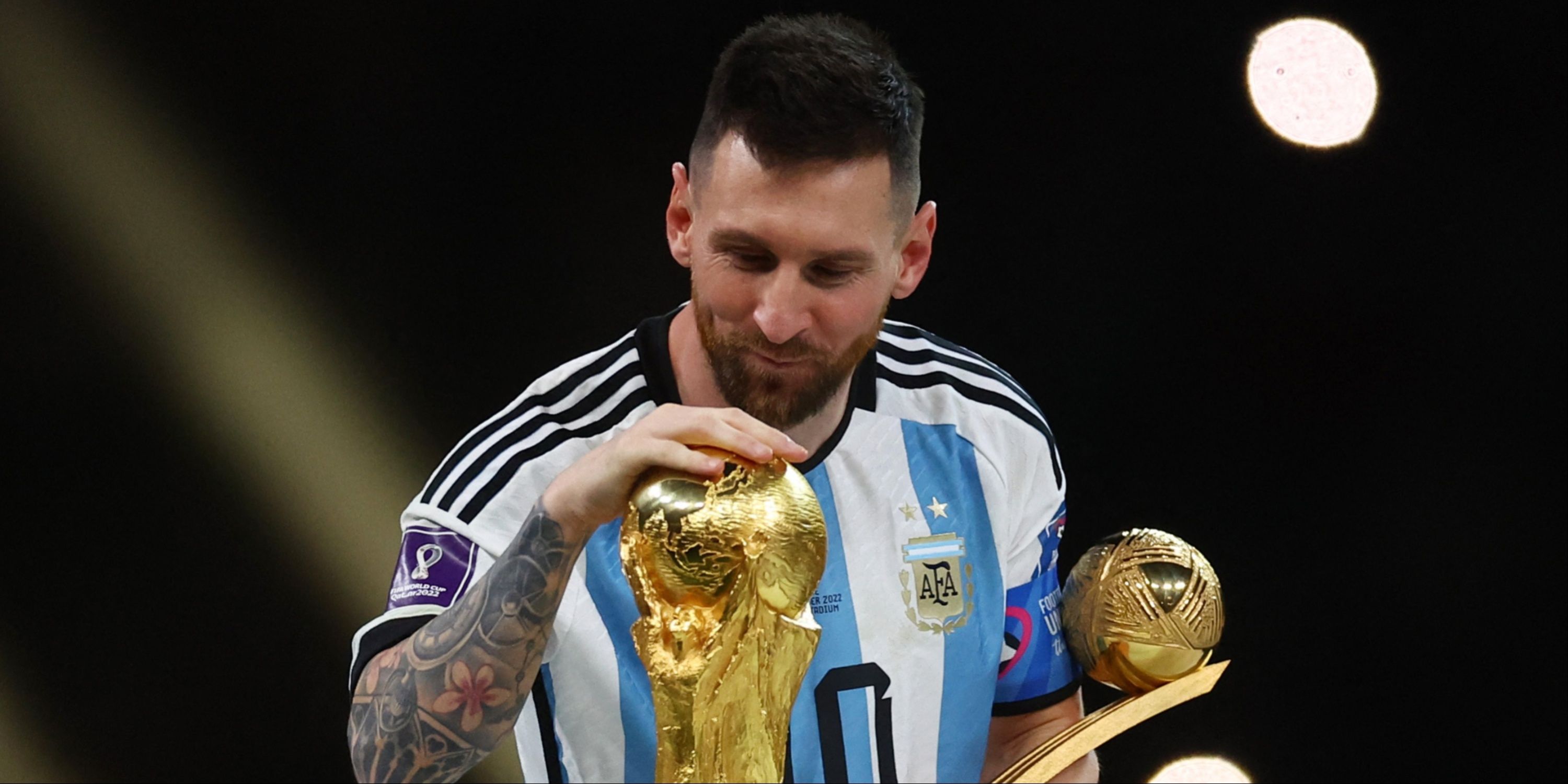 Argentina's Lionel Messi gazes lovingly at the World Cup trophy. 