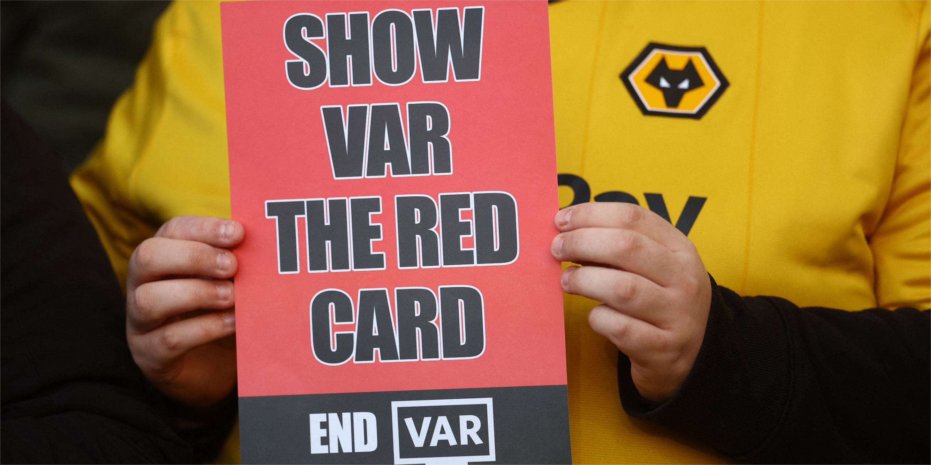 A Wolves fan holding up a poster which reads: 