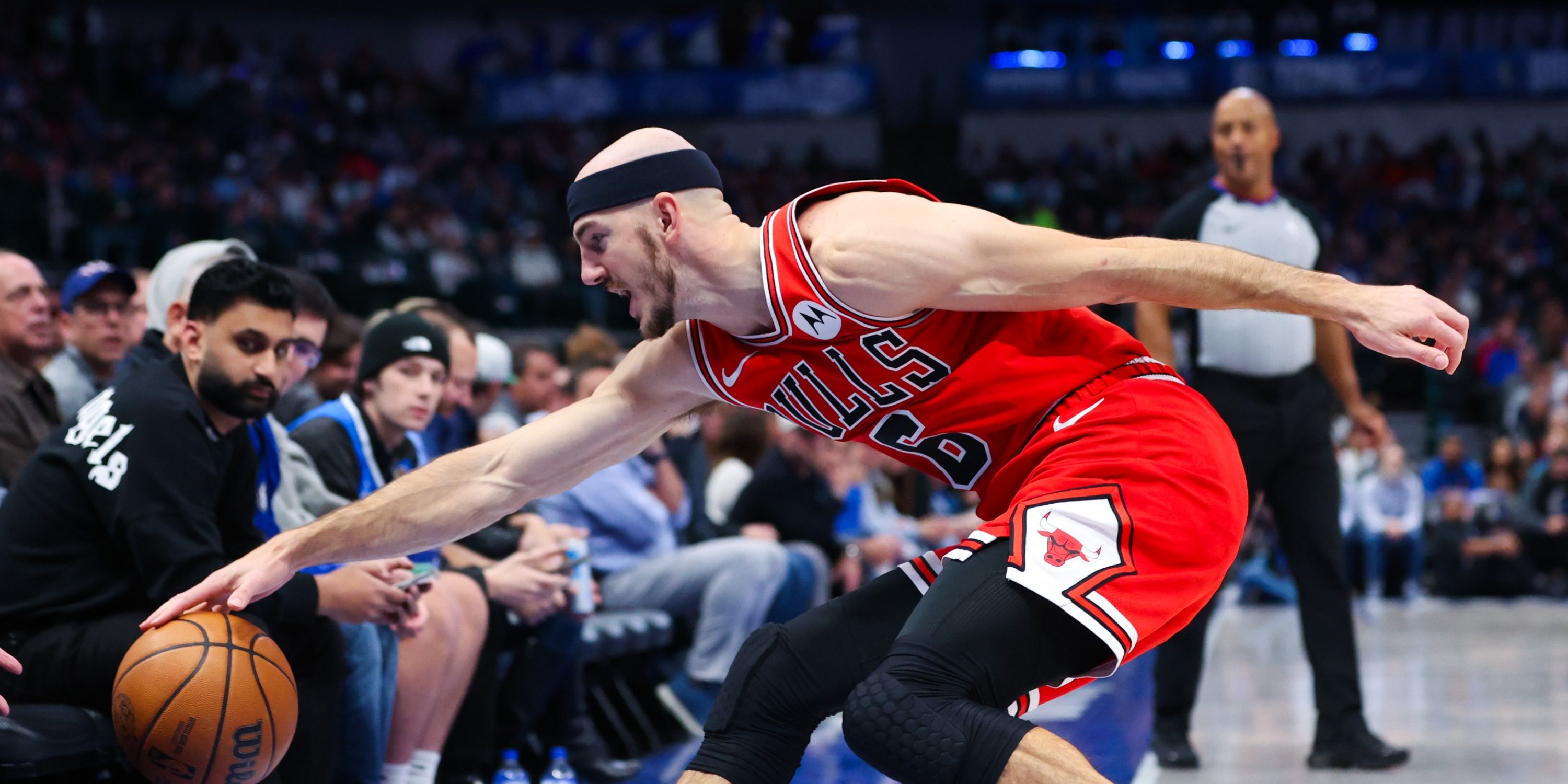 Alex Caruso of the Chicago Bulls dives for a loose ball during an NBA game.