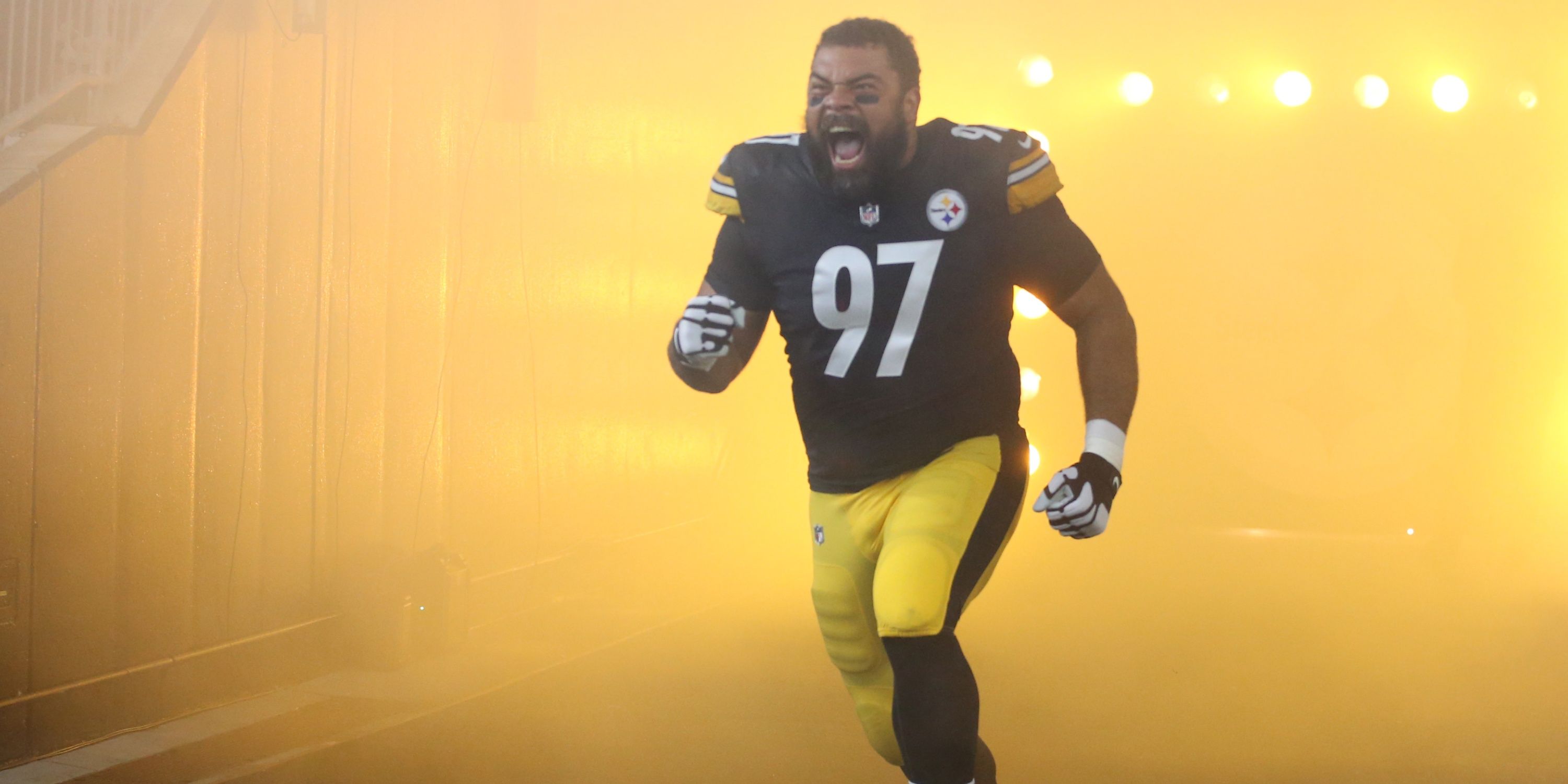 Cam Heyward running onto the field during a Steelers game.