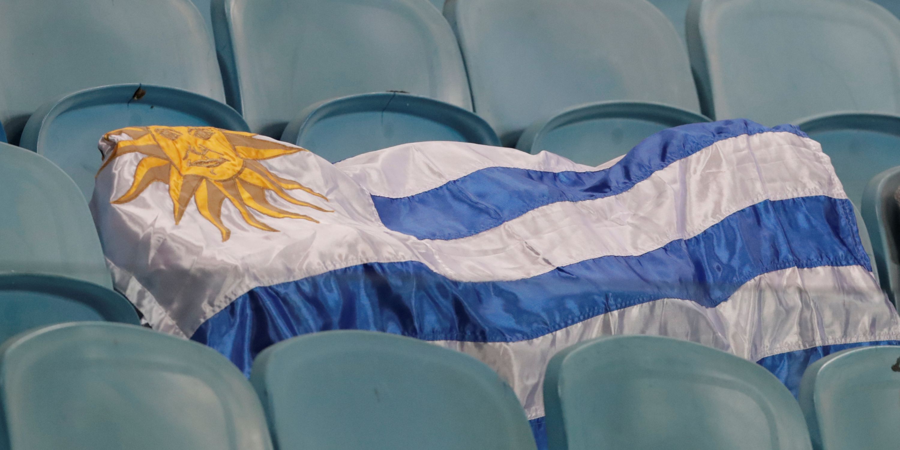 The Uruguay flag spread across some seats at a football stadium