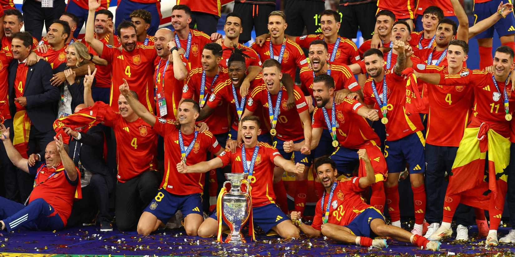 Spain players celebrate with the trophy after victory 