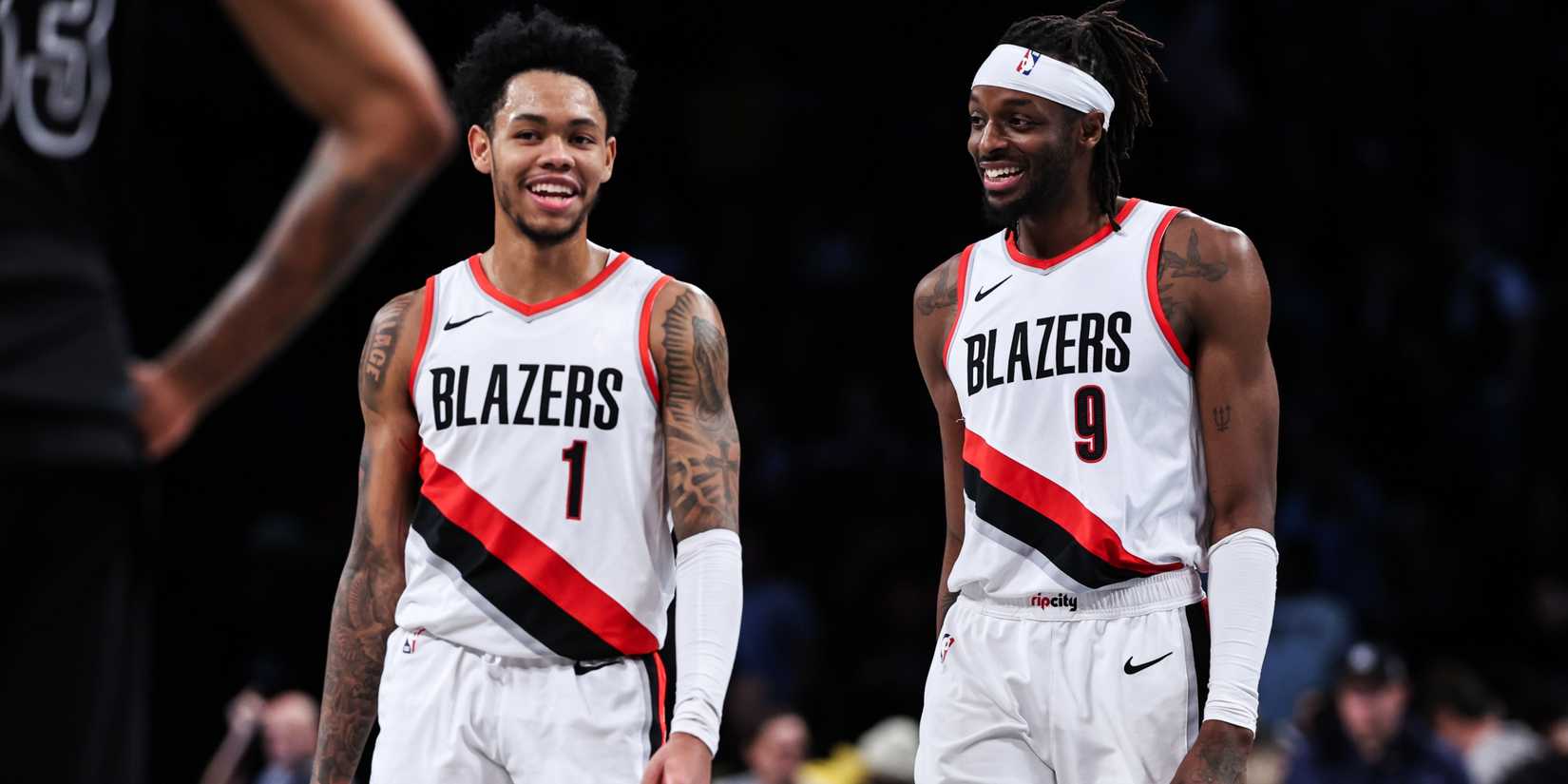 Jerami Grant, Anfernee Simons of the Portland Trail Blazers talk on the court.