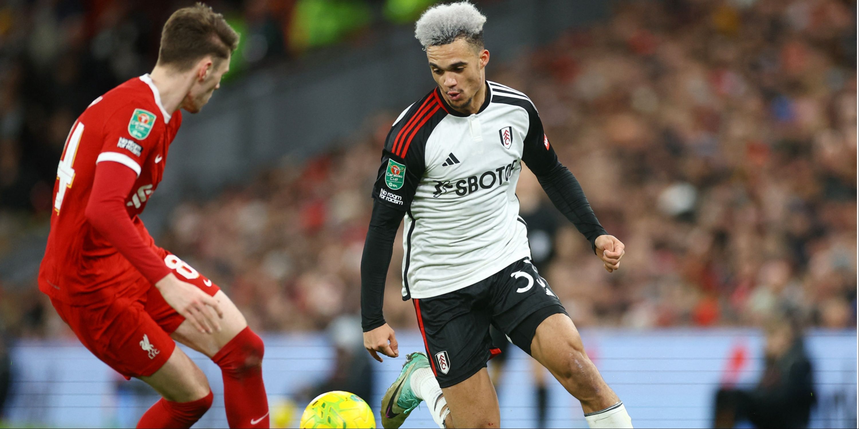 Fulham left-back Antonee Robinson attempting to take on Liverpool defender Conor Bradley