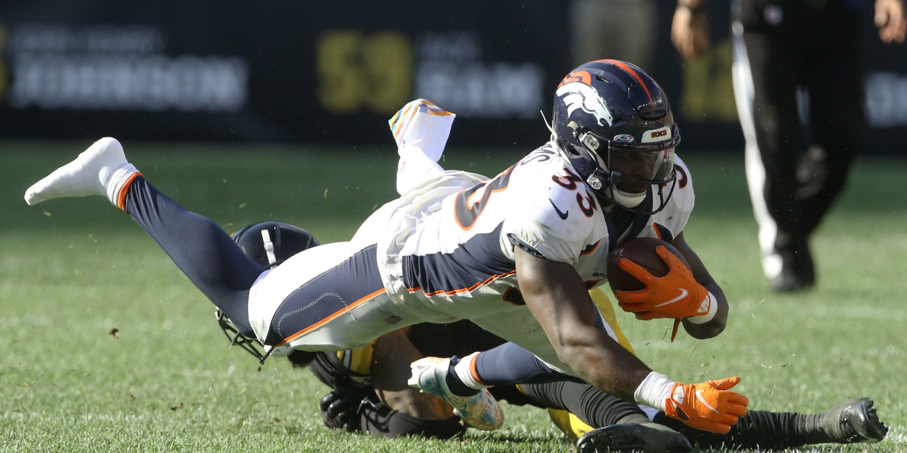 Pittsburgh, Pennsylvania, USA; Denver Broncos running back Javonte Williams (33) dives for additional yardage against Pittsburgh Steelers cornerback Arthur Maulet (rear) during the fourth quarter at Heinz Field. 