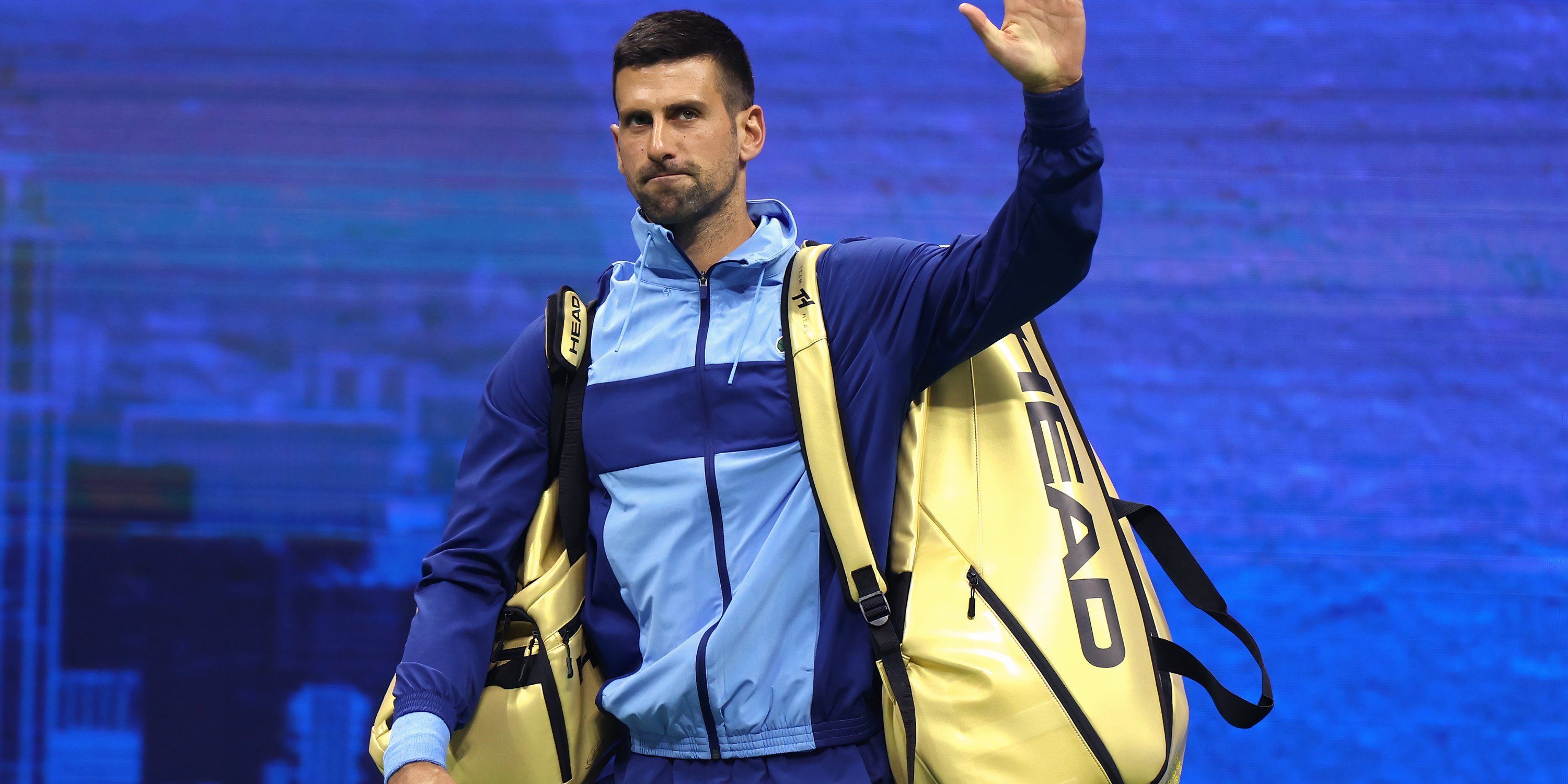 Novak Djokovic carries two gold bags into the US Open