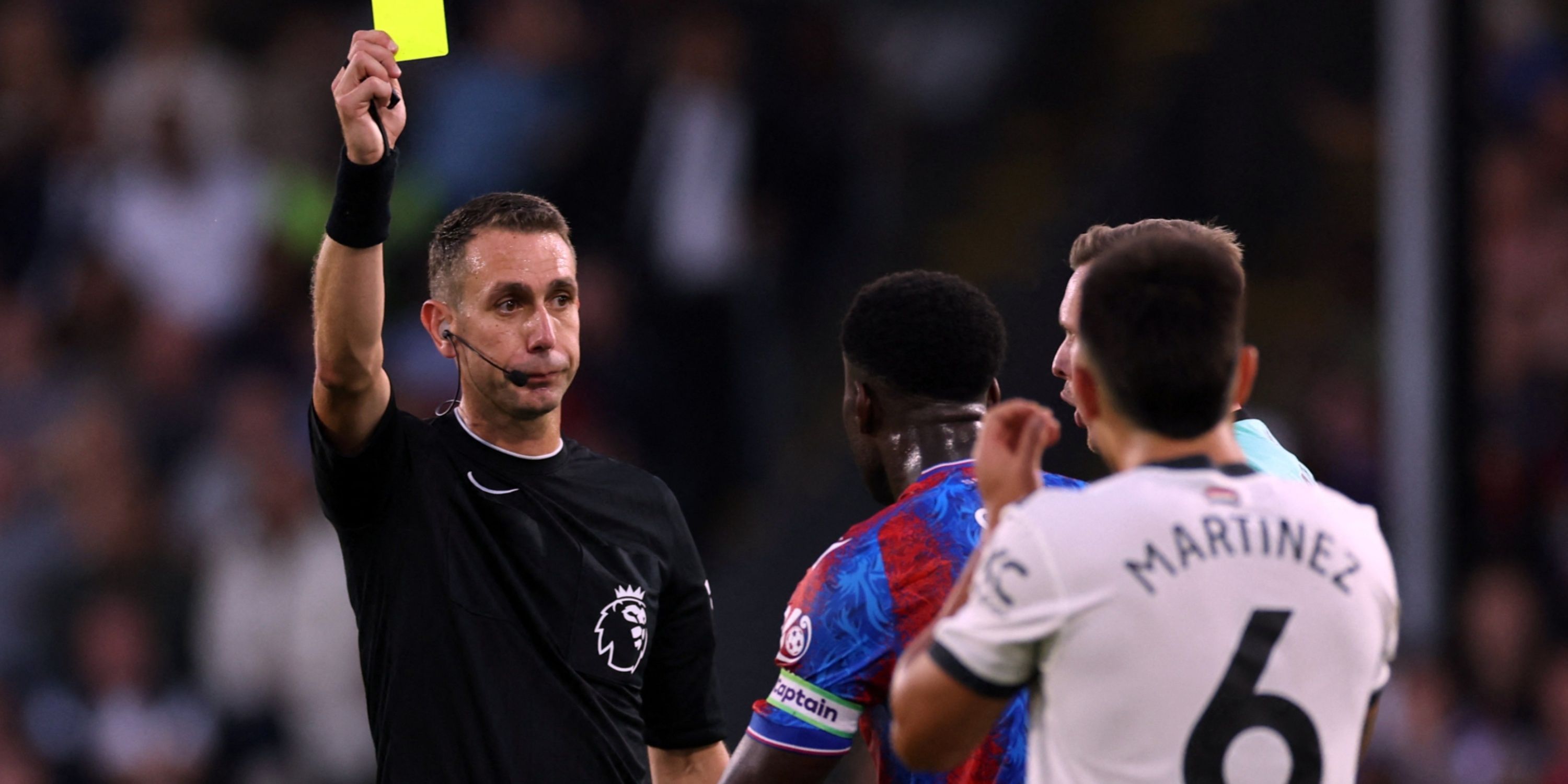 Manchester United's Lisandro Martinez is shown a yellow card by referee David Coote