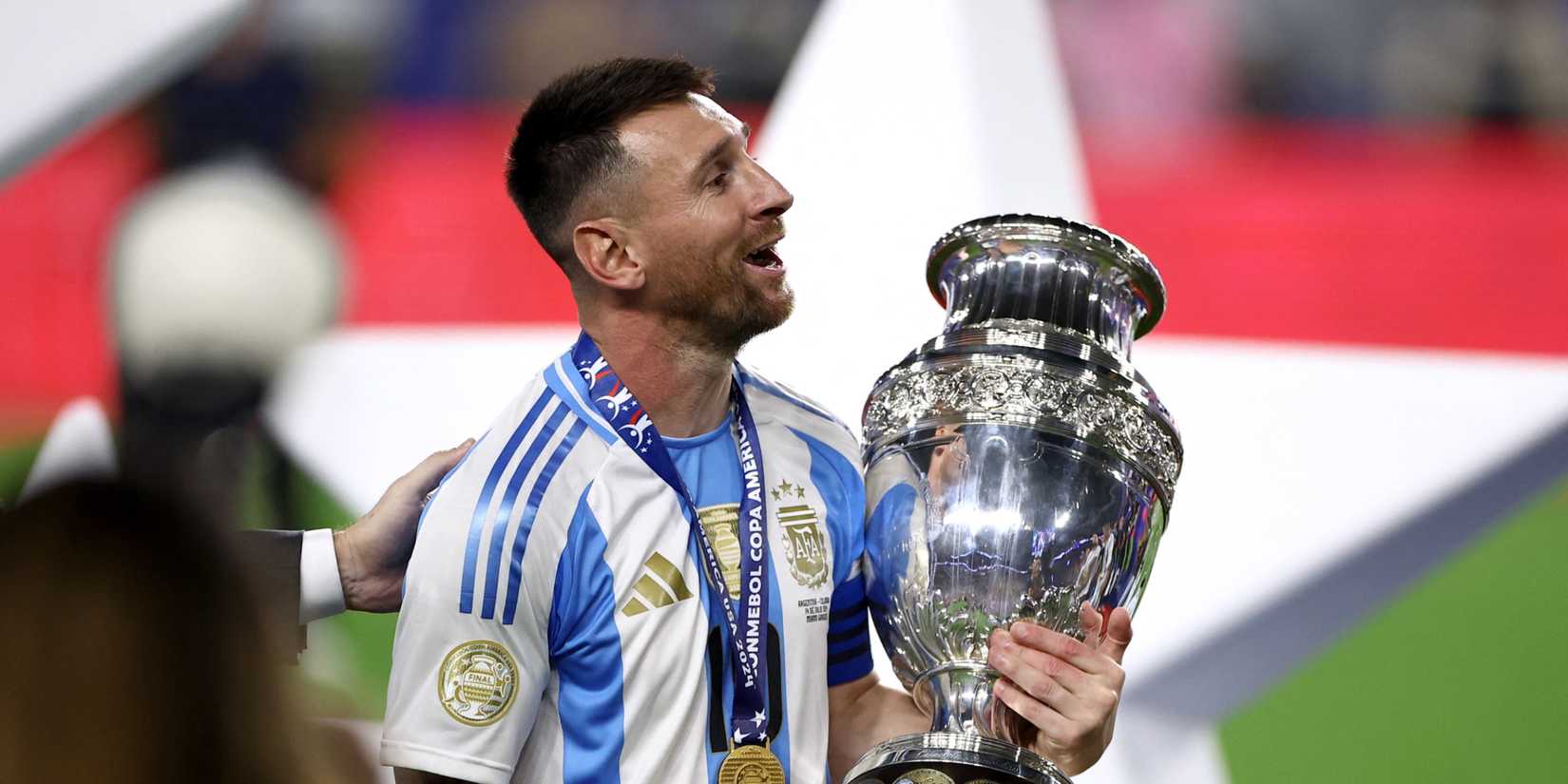 Lionel Messi holding the Copa America trophy.