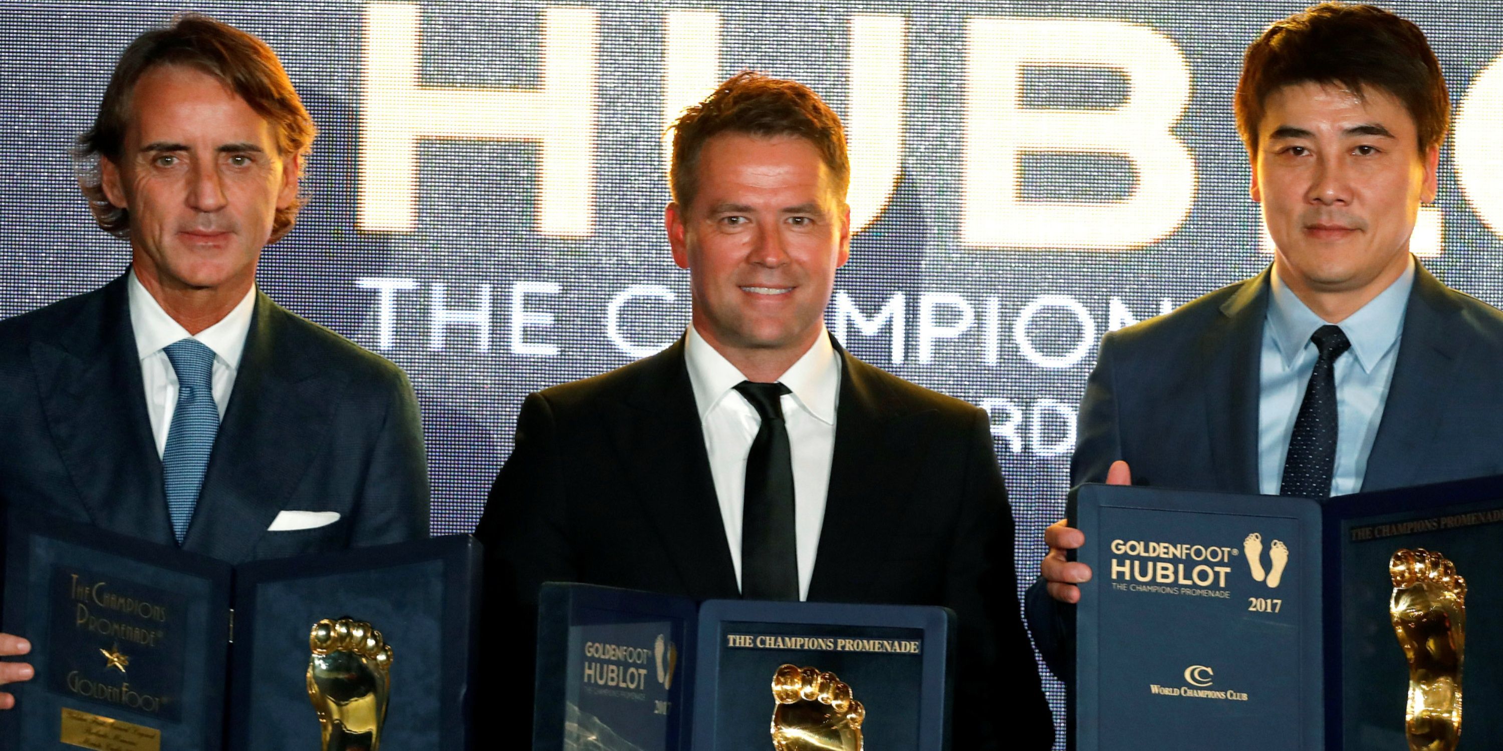 Former soccer players Roberto Mancini, Michael Owen and Li Ming pose after receiving their Golden Football Legend Award