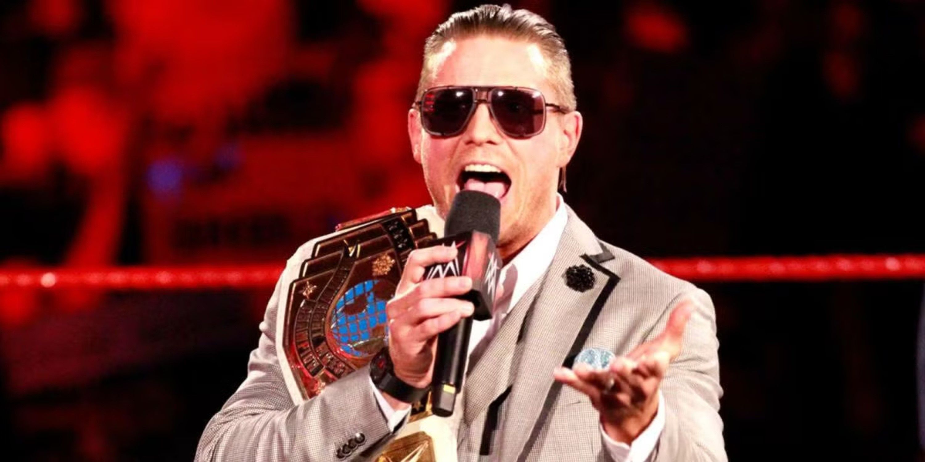 The Miz talking into a microphone while holding the WWE Intercontinental Championship