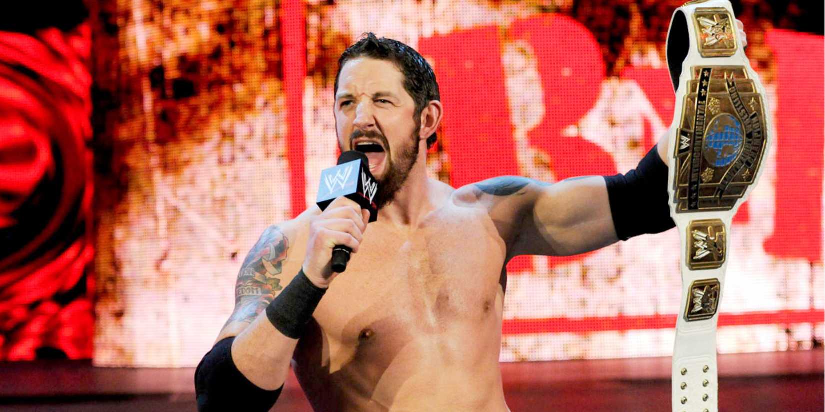 WWE's Wade Barrett holding a microphone and raising the Intercontinental Championship