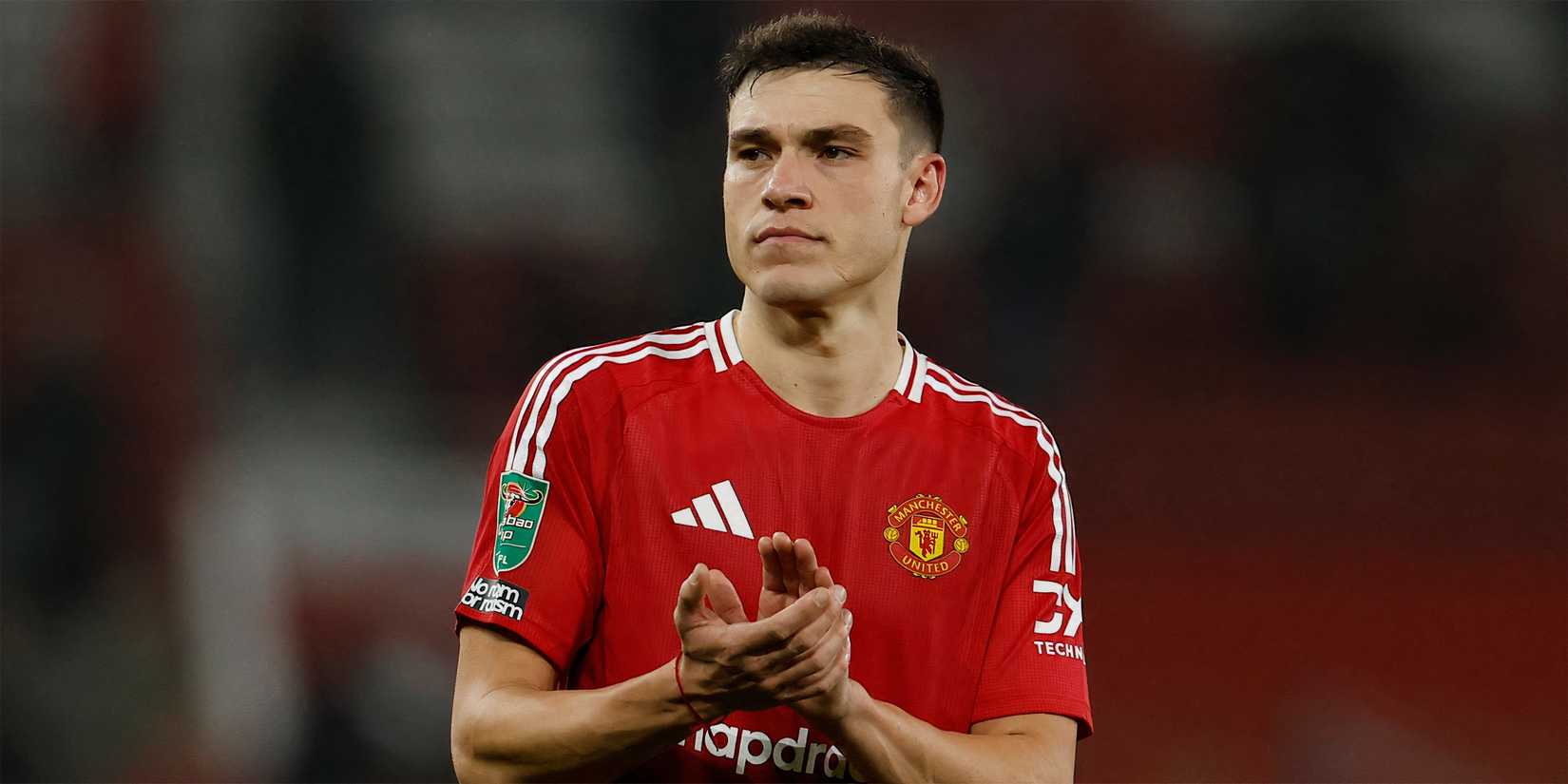 Manuel Ugarte applauding the Manchester United supporters