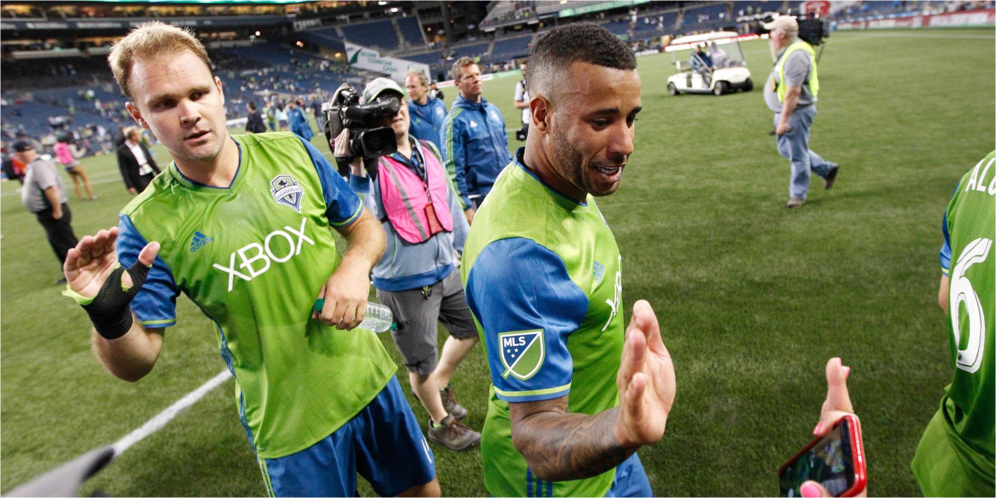 Seattle Sounders defender Chad Marshall (left) and defender Tyrone Mears (right) slap hands with fans after a game against the San Jose Earthquakes at CenturyLink Field