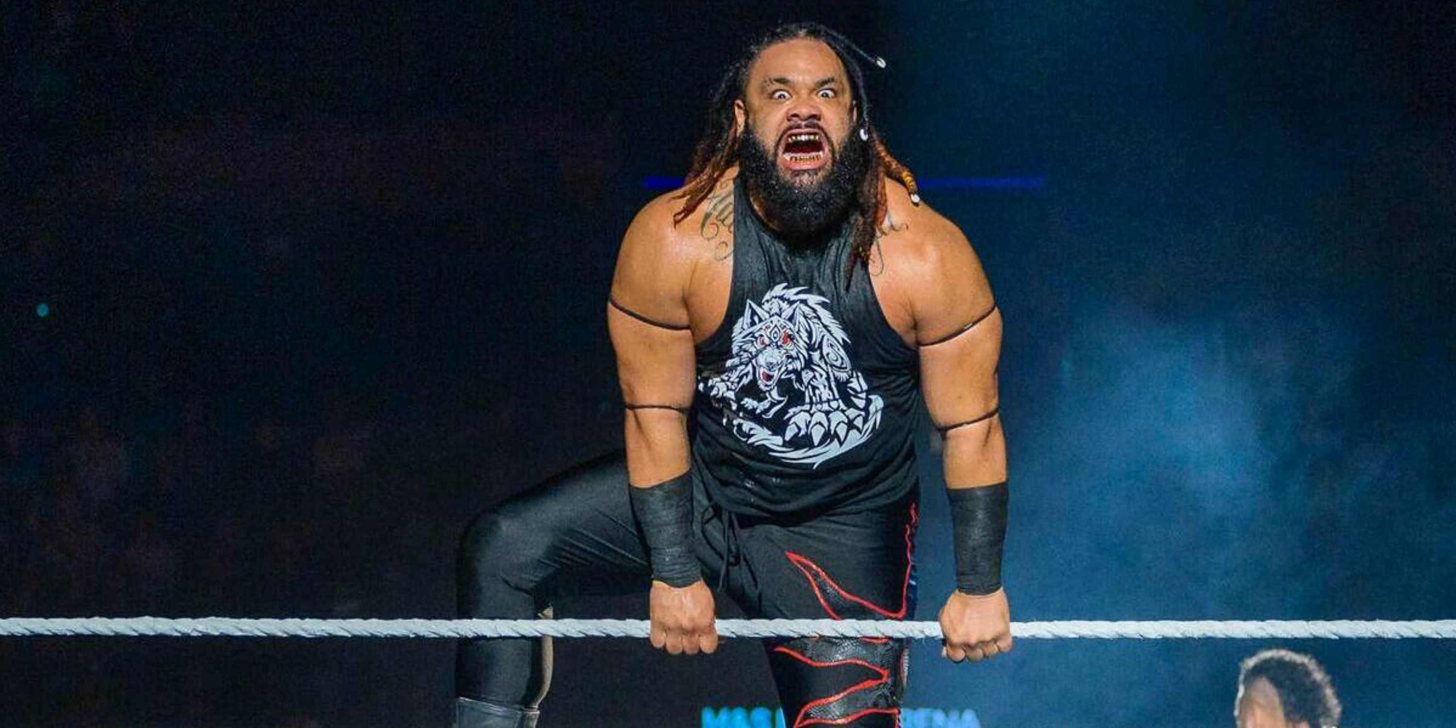 WWE's Jacob Fatu hanging over the ropes.