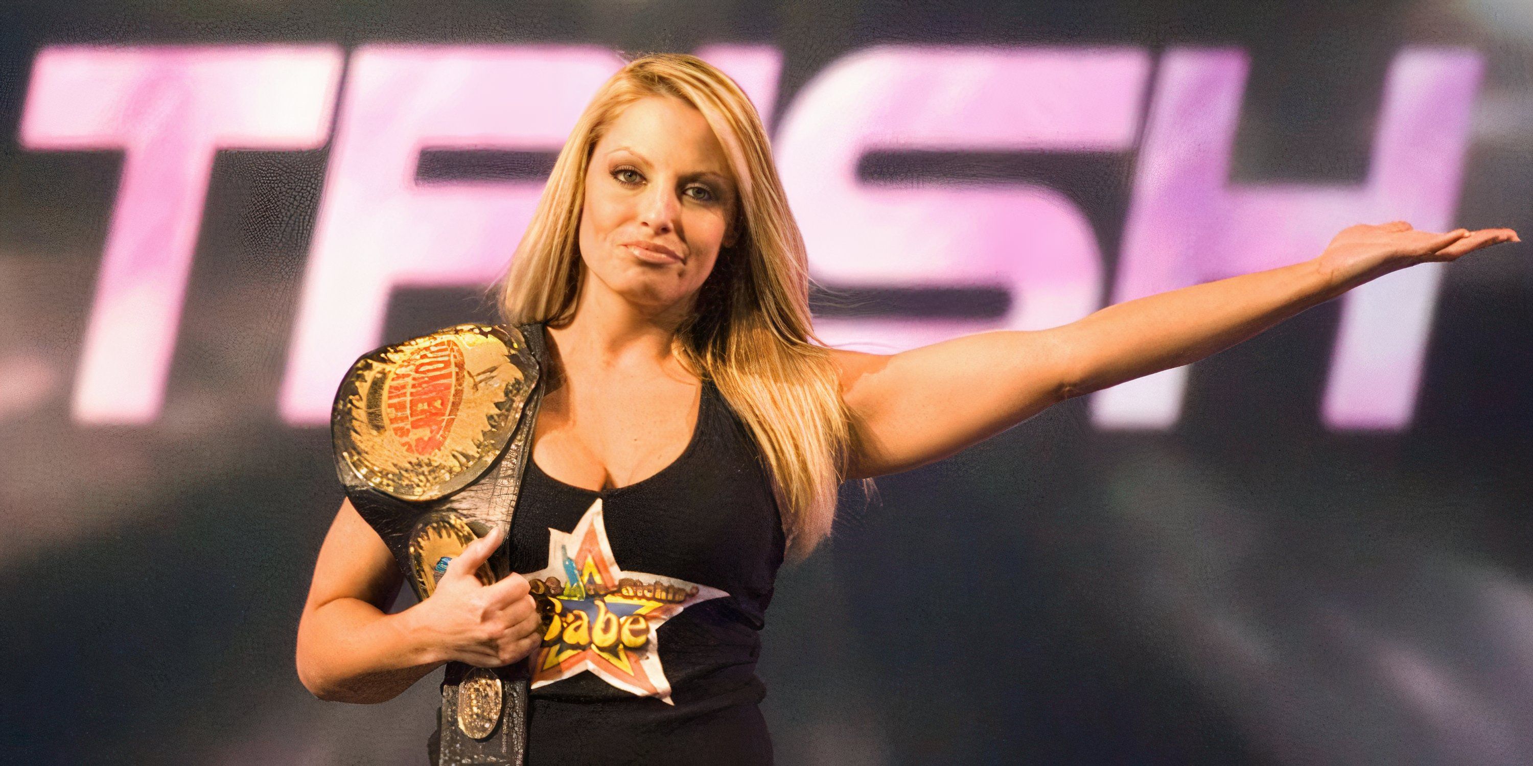 Trish Stratus poses with the WWE Women's Championship.