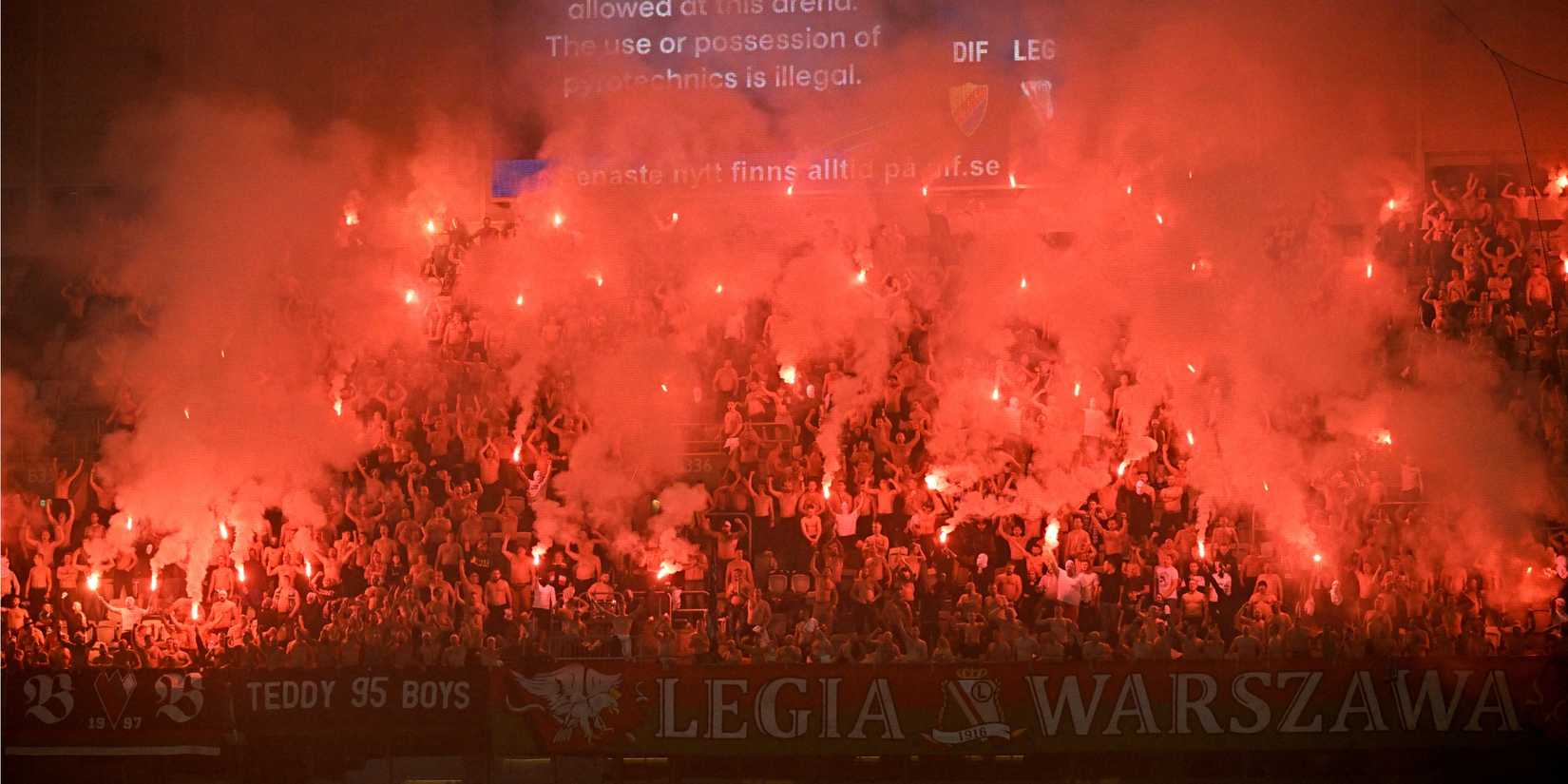 Legia Warsaw fans with flares in the stands