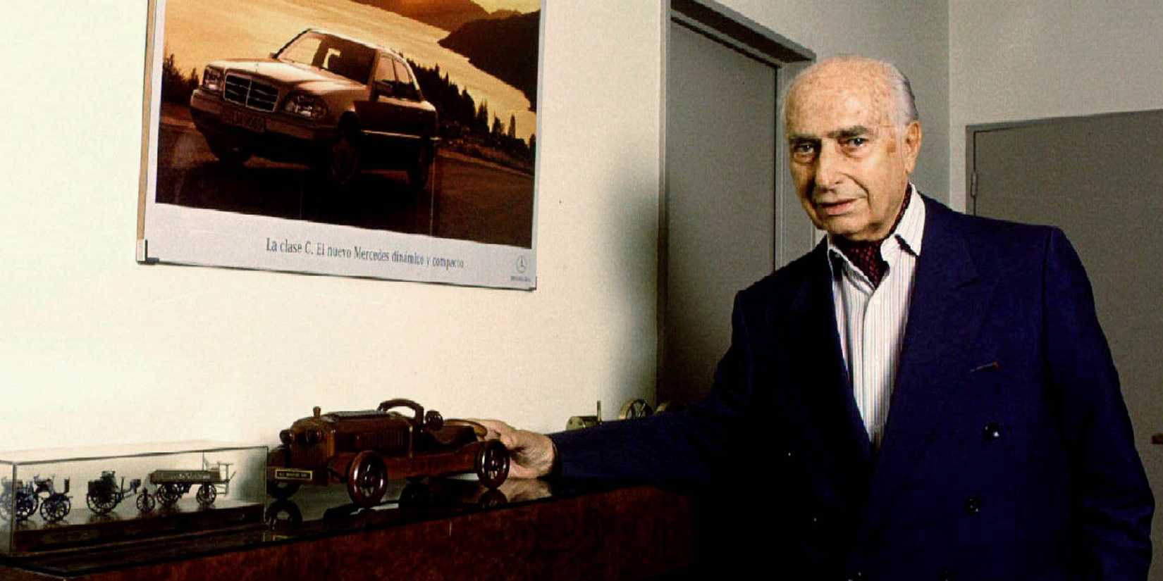 Juan Manuel Fangio next to a model of one of the cars that he drove during his long Formula One career.