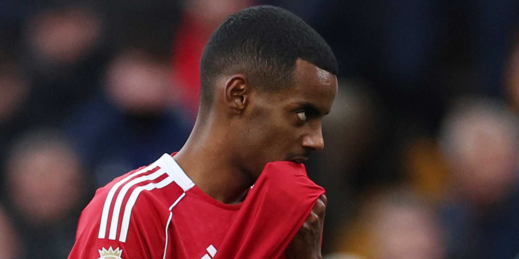 Liverpool's Alexander Isak bites his shirt.