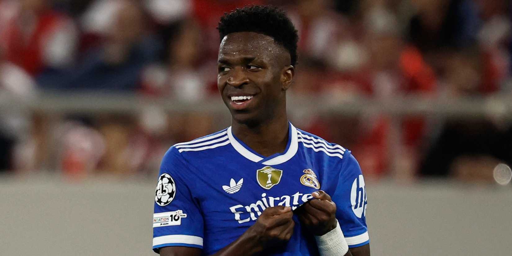 Vinicius Junior holds the Real Madrid club badge on his shirt