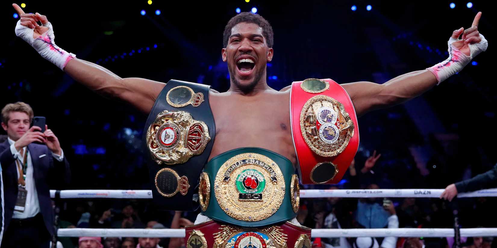 Anthony Joshua celebrates with his belts after beating Andy Ruiz Jr