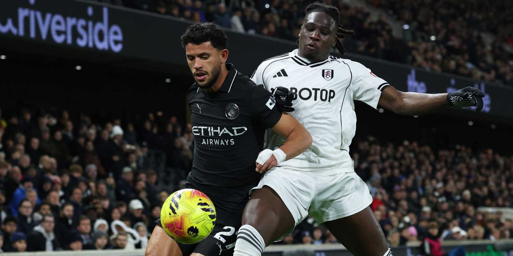 Fulham's Calvin Bassey challenges Manchester City's Matheus Nunes for the ball.