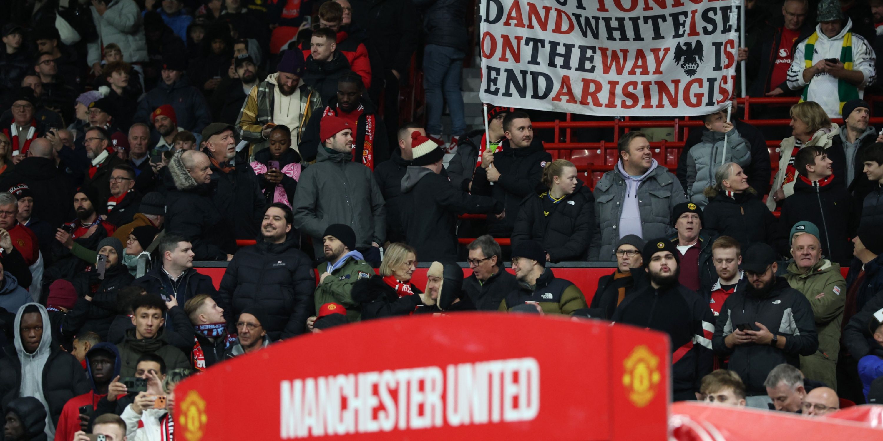 Manchester United fans hold up a banner at Old Trafford.