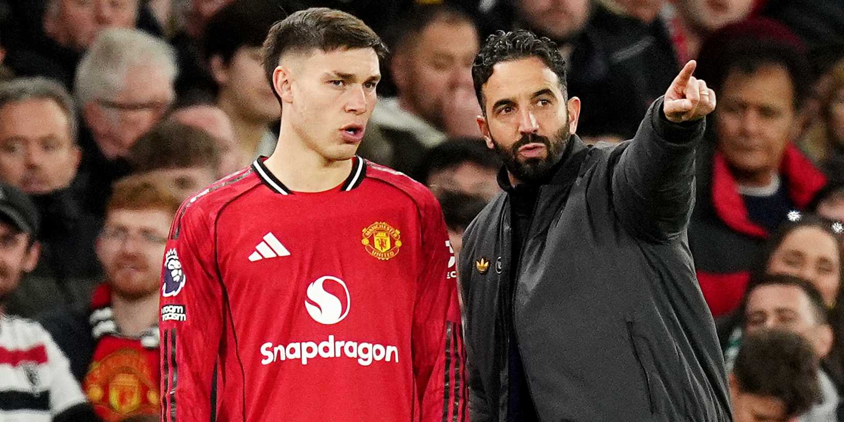 Manchester United manager Ruben Amorim (right) speaks to Manuel Ugarte