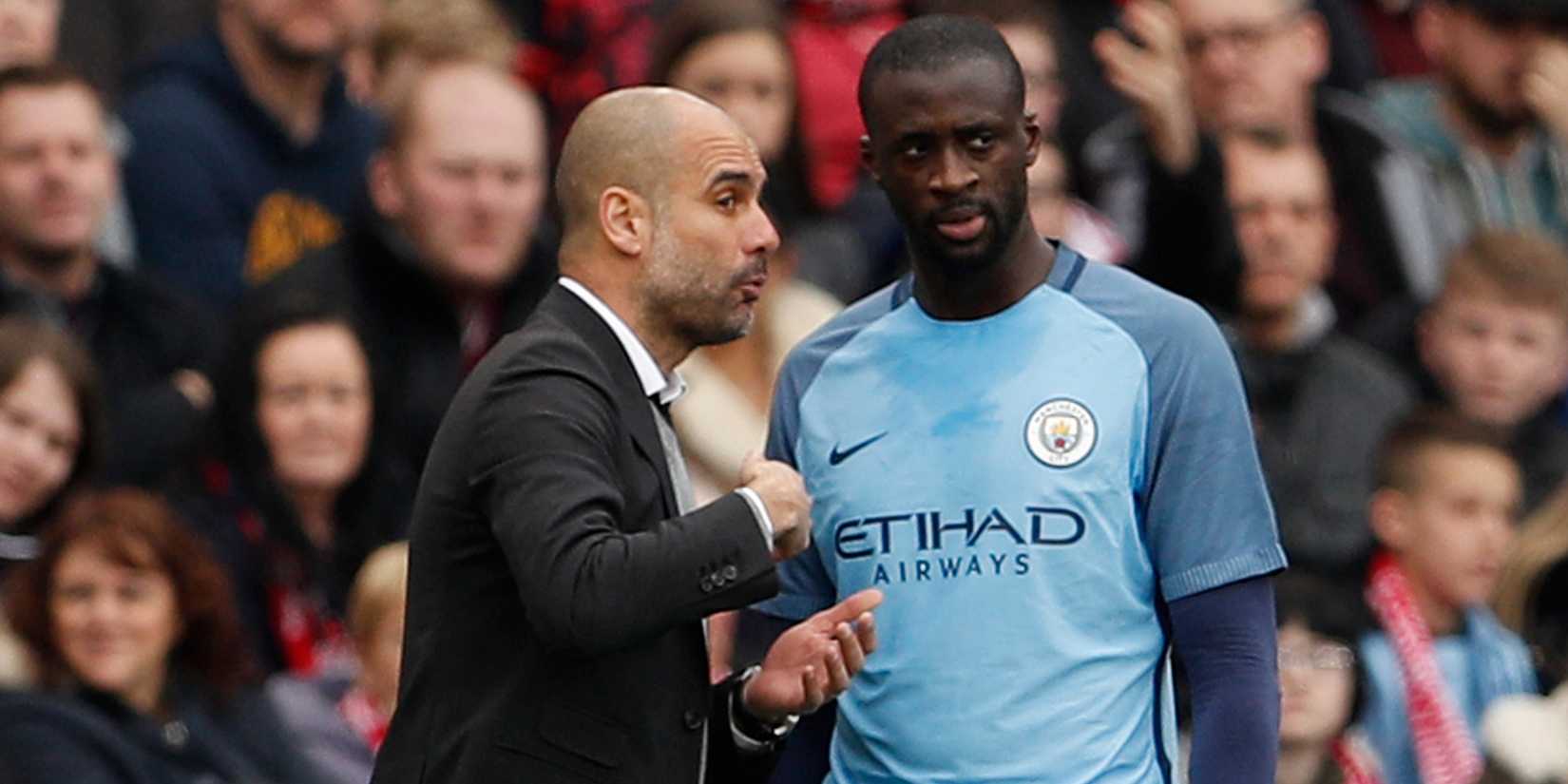 Manchester City manager Pep Guardiola speaking to Yaya Toure.