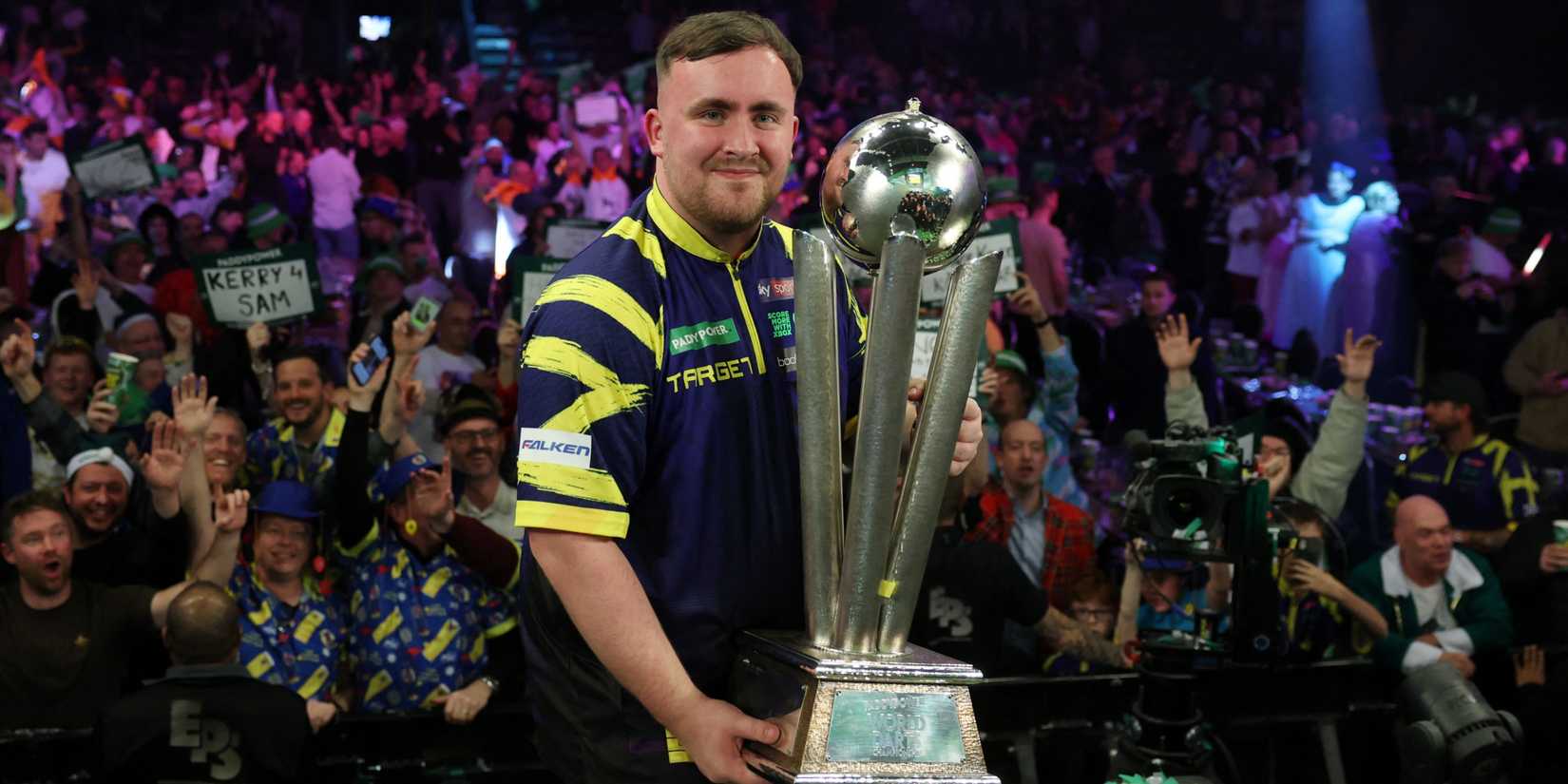 Luke Littler poses with the trophy after winning the World Darts Championship