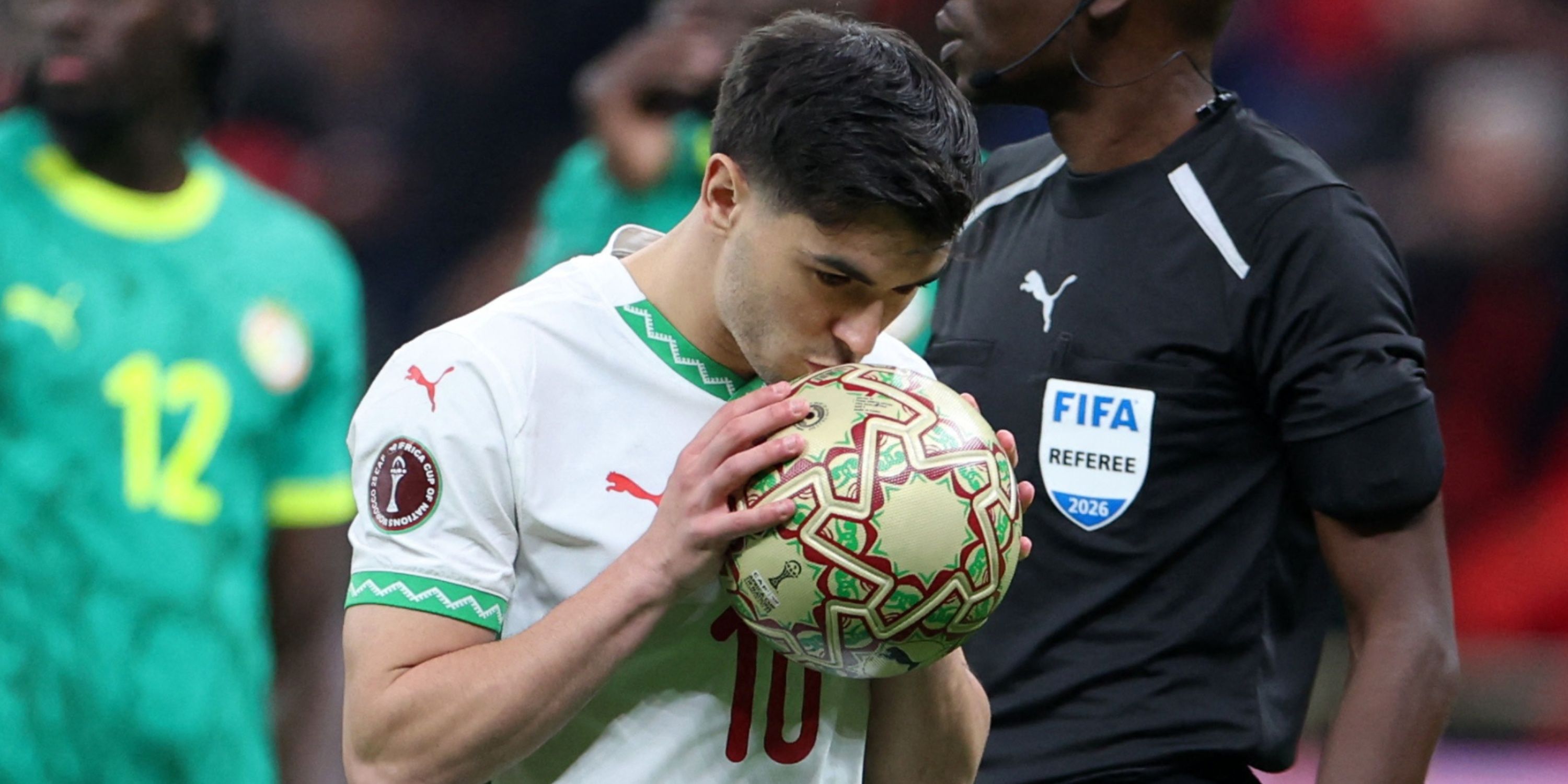 Morocco's Brahim Diaz kisses the ball as he prepares to take a penalty vs Senegal