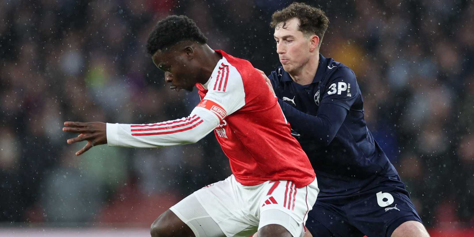 Arsenal's Bukayo Saka in action with Wigan Athletic's Jensen Weir