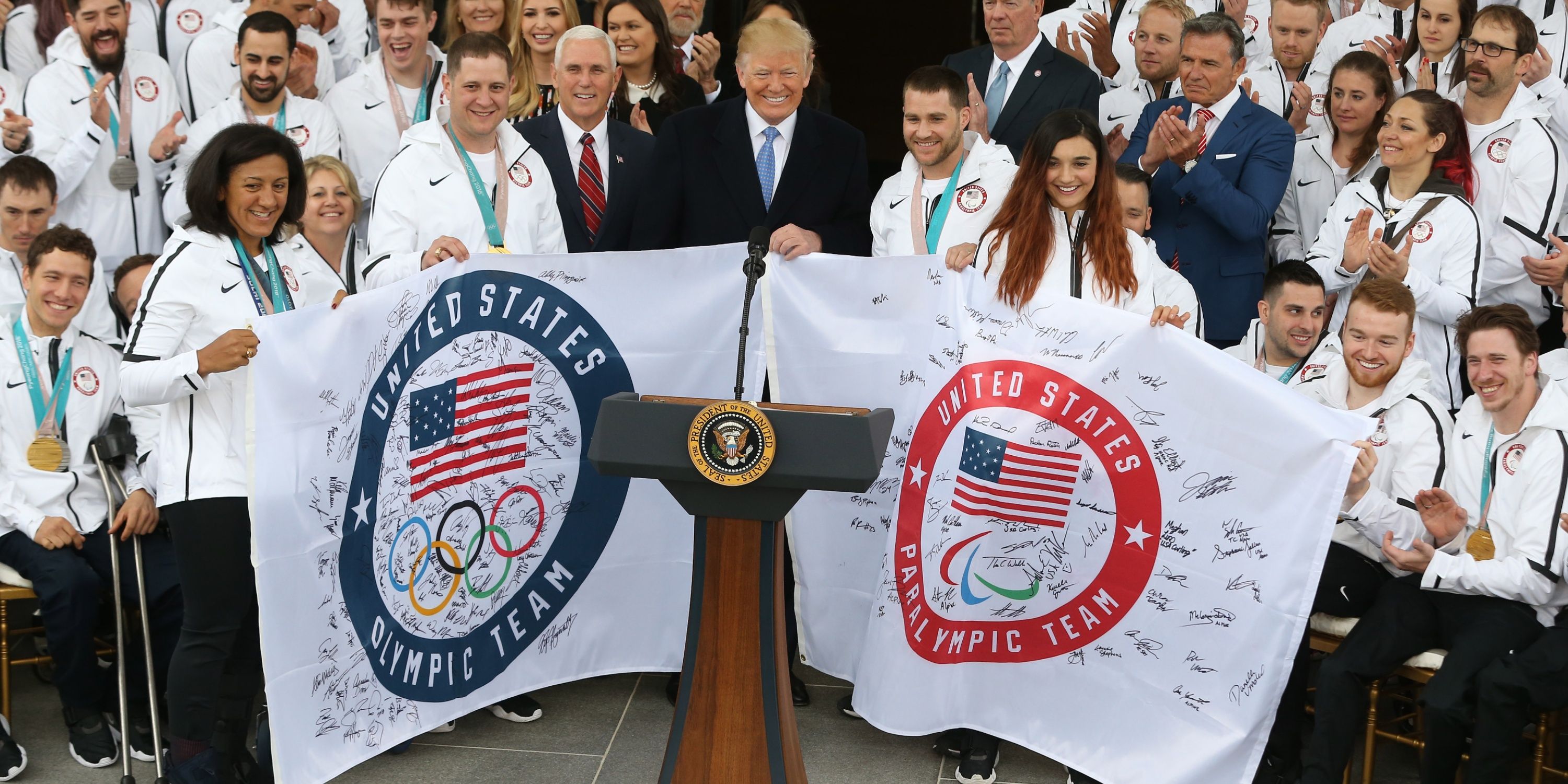President Donald Trump holds gift signed flags at a ceremony honoring Team USA Olympic and Paralympic athletes from the 2018 PyeongChang Winter Olympics 