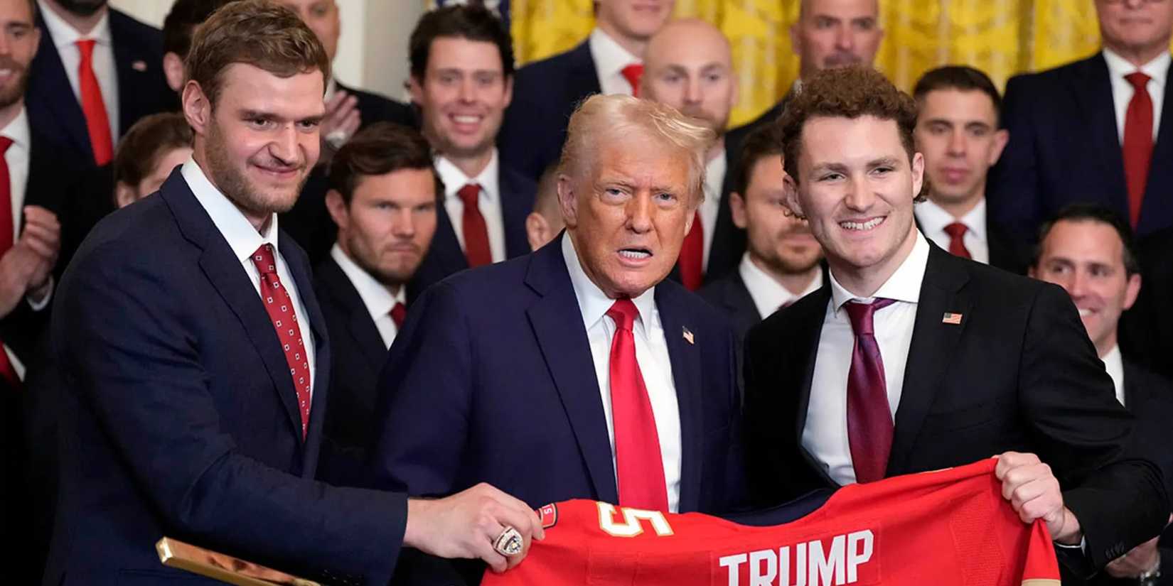 President Donald Trump, center, poses for a photo with Aleksander Barkov, left, and Matthew Tkachuk with a jersey and a hockey stick