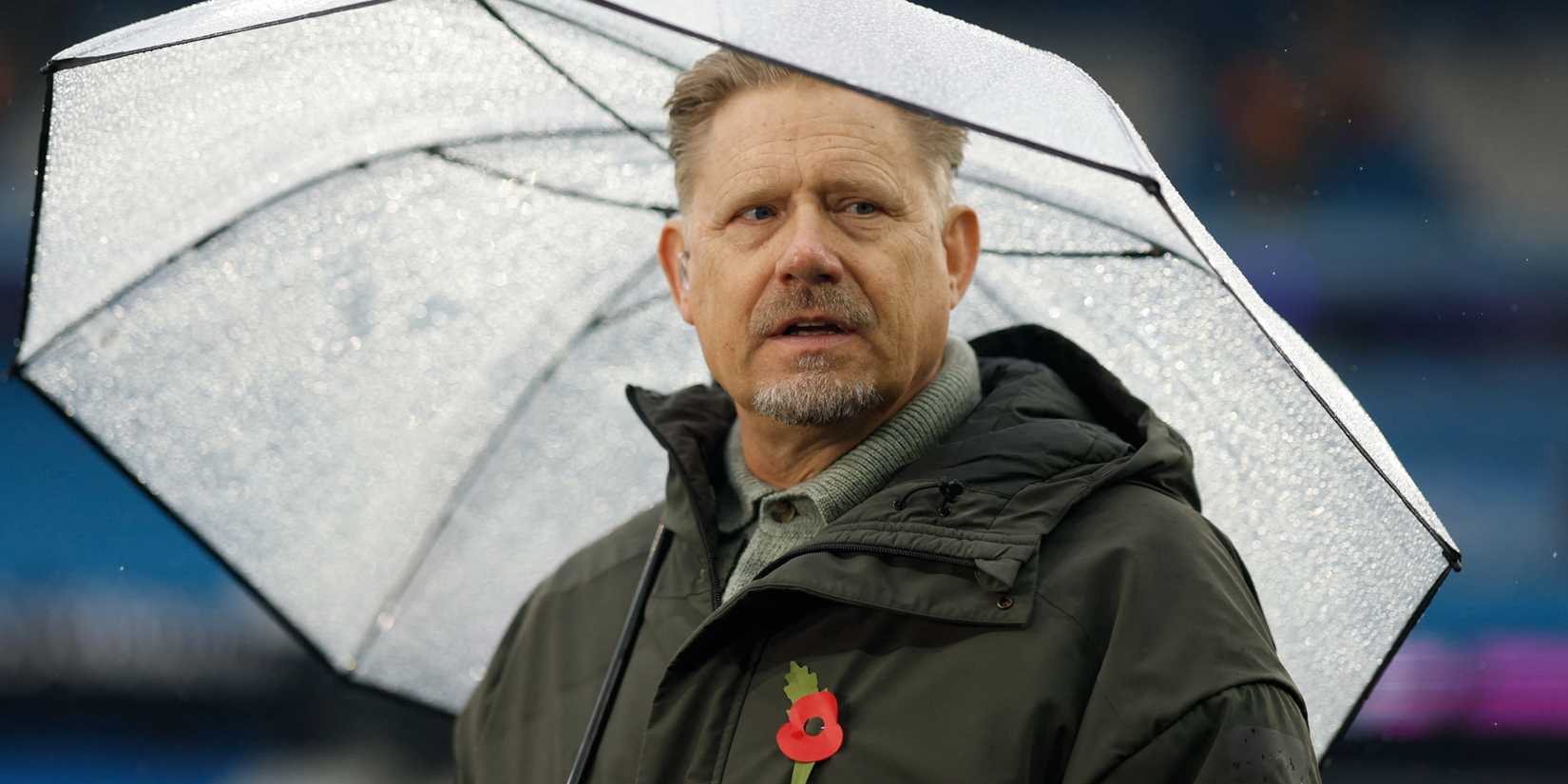 Former Manchester City player Peter Schmeichel holding an umbrella