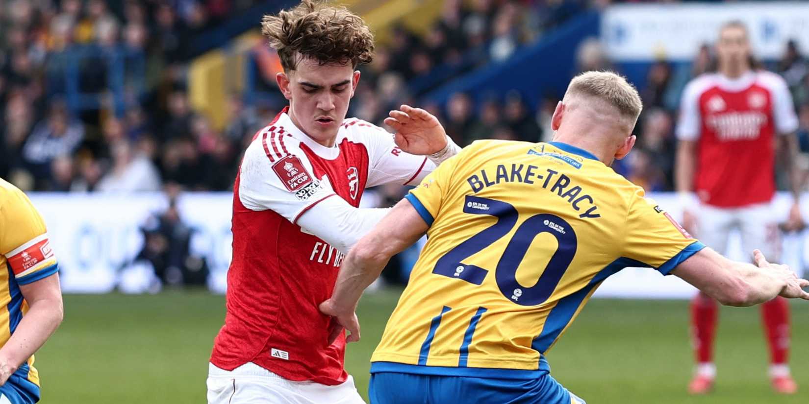 Mansfield Town's Louis Reed and Mansfield Town's Frazer Blake-Tracy in action with Arsenal's Max Dowman