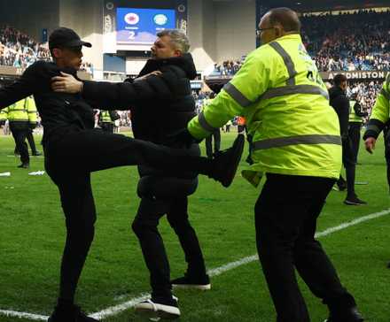 Rangers fan clashes with a steward on the pitch after the Celtic match