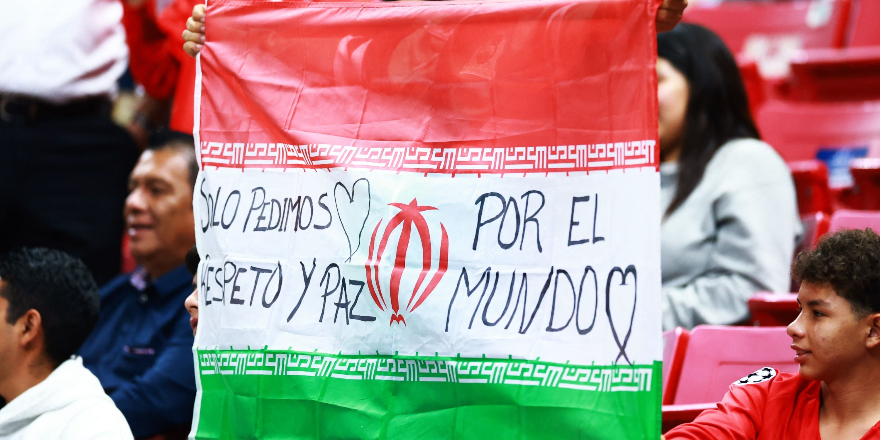 A fan holds up the flag of Iran in the stands before the match between New Caledonia v Jamaica