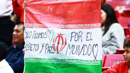 A fan holds up the flag of Iran in the stands before the match between New Caledonia v Jamaica