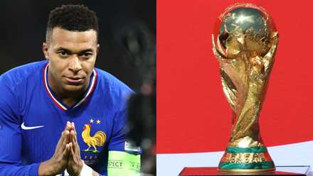 France's Kylian Mbappe makes a prayer sign and the FIFA World Cup trophy is displayed