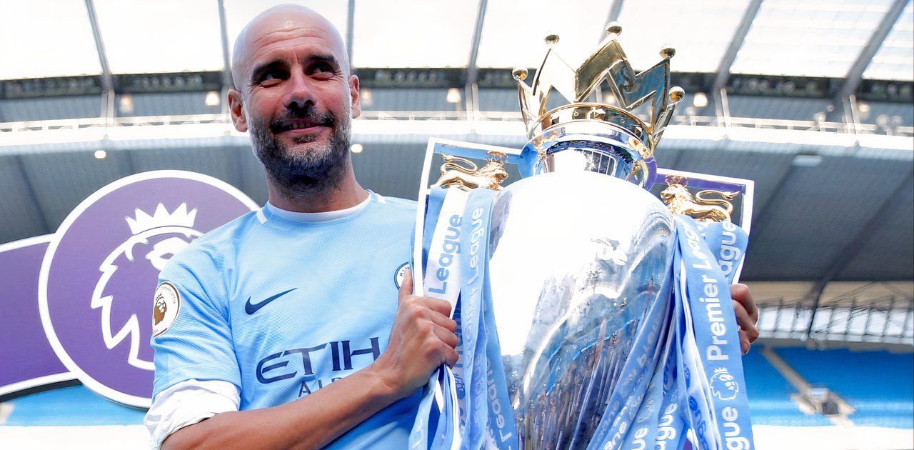 Pep Guardiola celebrates with the Premier League trophy